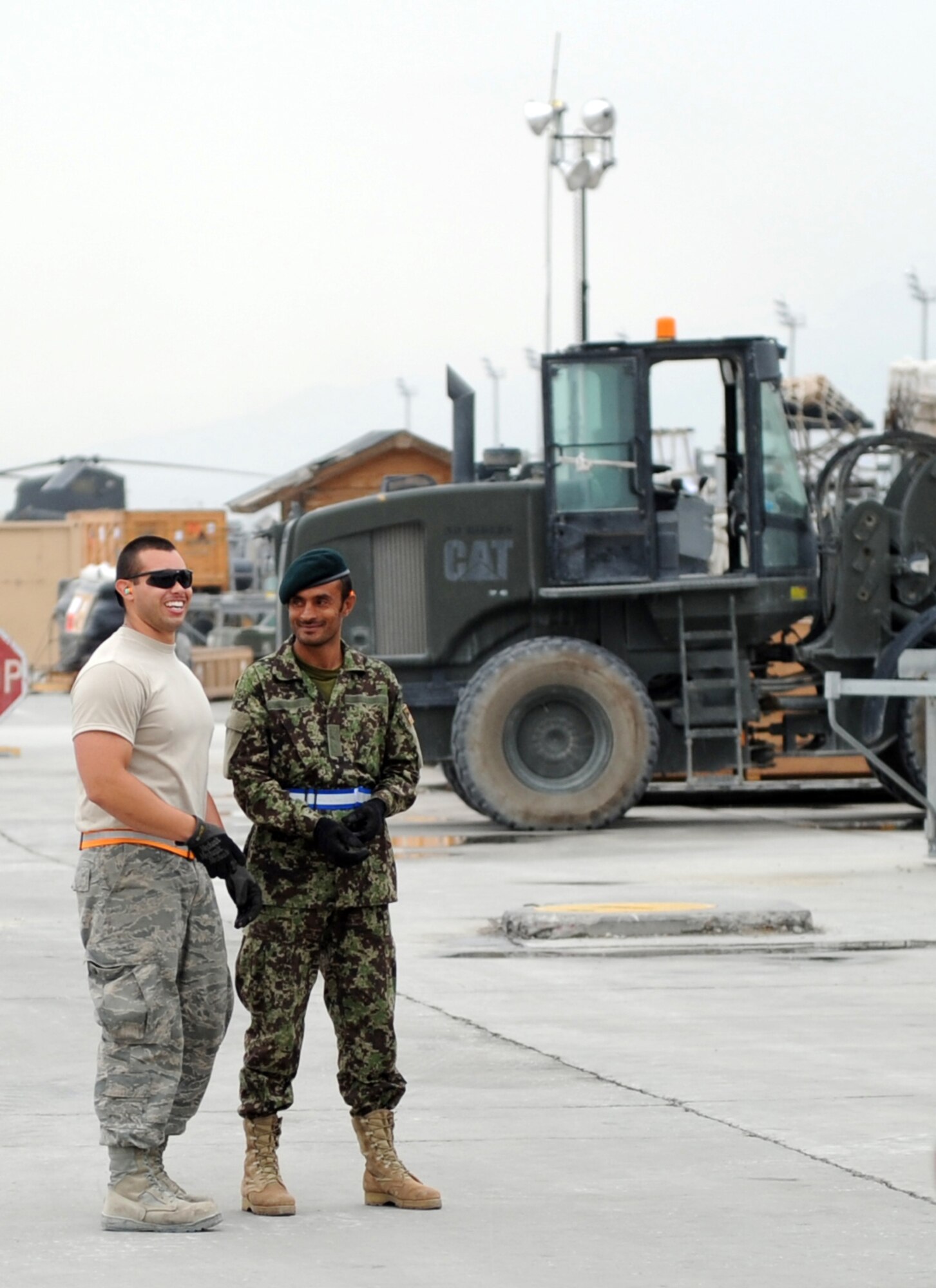 Senior Airman Michael Cepeda, an aerial porter with the 455th Expeditionary Aerial Port Squadron, enjoys a laugh during training with an Afghan aerial porter July 28, 2010 at Bagram Airfield, Afghanistan. (U.S. Air Force photo/Tech. Sgt. Drew Nystrom)