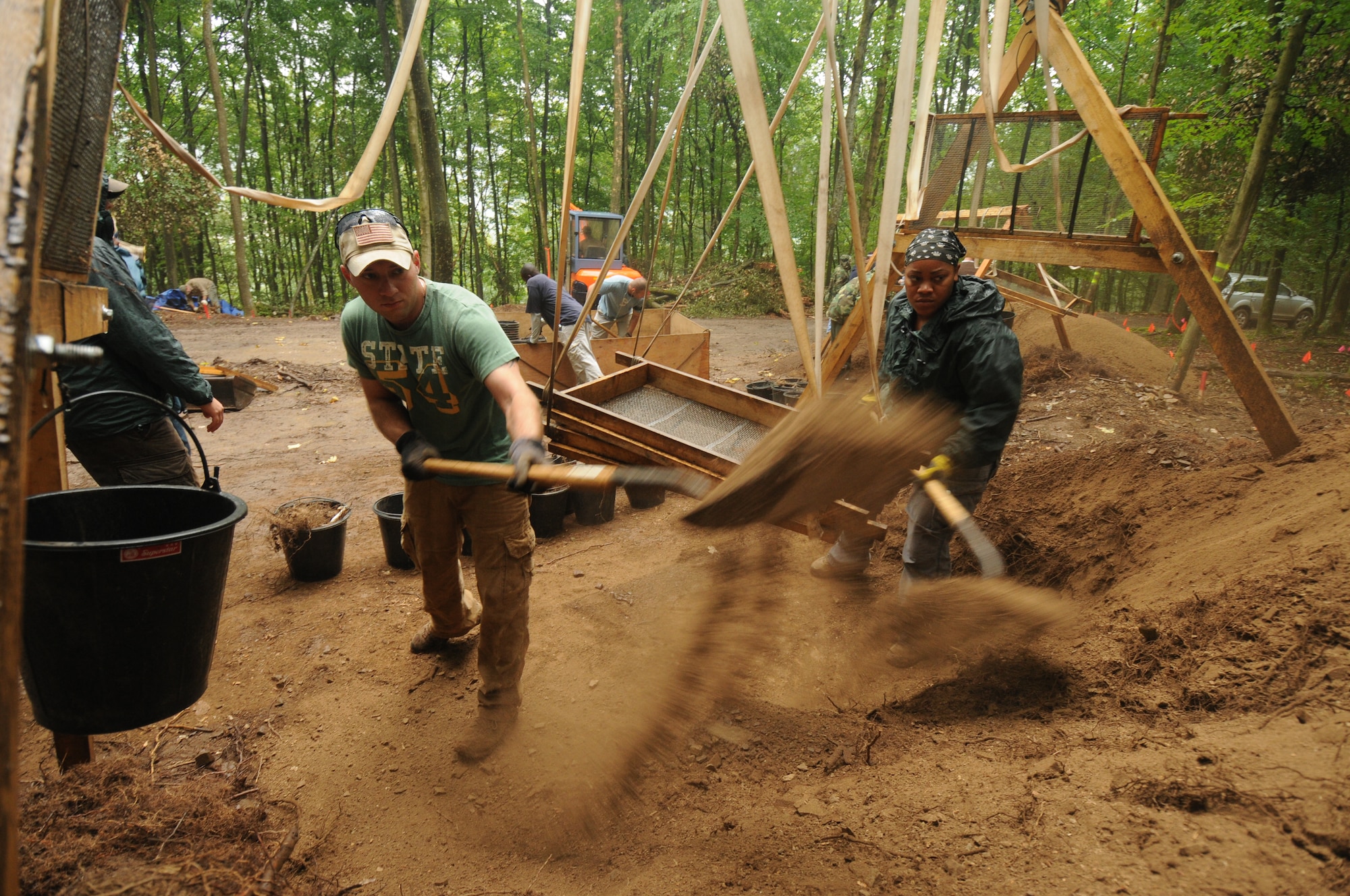 RHEINLAND-PFALZ, Germany – Army Staff Sgt. Ryszard Tella, left, and Air Force Staff Sgt. Alceve Lawrence, both from the Joint Prisoners of War/Missing in Action Accounting Command, shovel dirt from a sifting station during the last day of digging during their mission July 28. The mission of the JPAC is to achieve the fullest possible accounting of all Americans missing as a result of the nation's past conflicts. (U.S. Air Force photo/Staff Sgt. Benjamin Wilson)