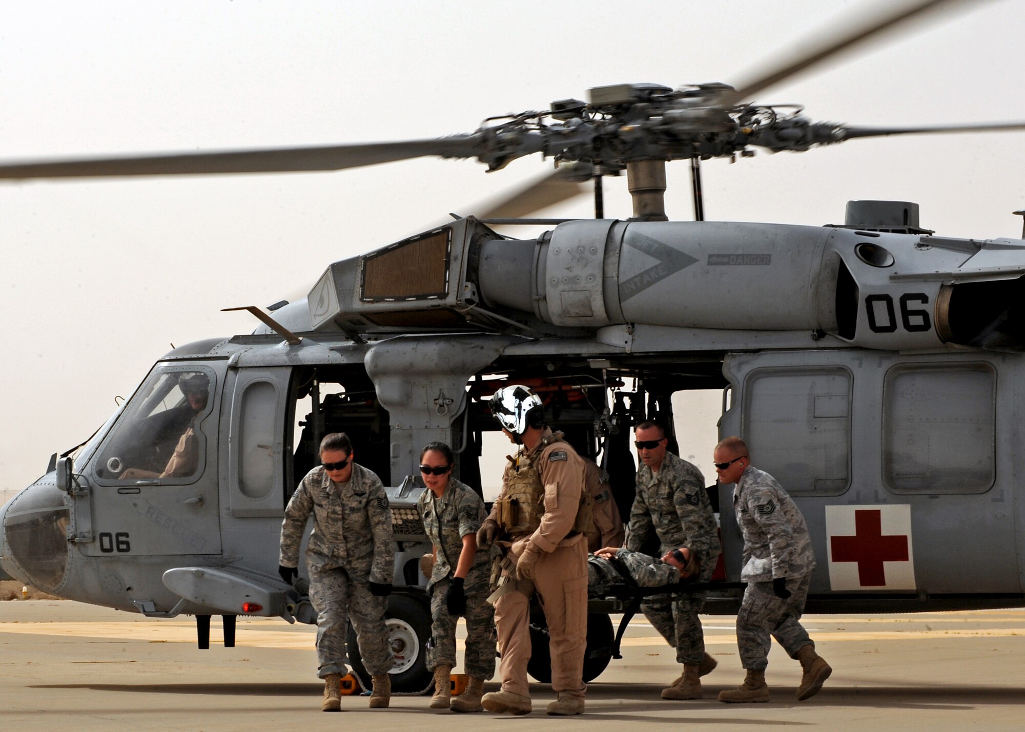 386th Expeditionary Medical Group Airmen remove a mock patient from a U.S. Navy MH-60 Sierra helicopter here July 22 as part of refresher litter training. The training is provided to familiarize Airmen on the loading and extraction of patients during medical evacuation missions in support of operations Enduring Freedom and Iraqi Freedom. (U.S. Air Force photo by Senior Airman Laura Turner)