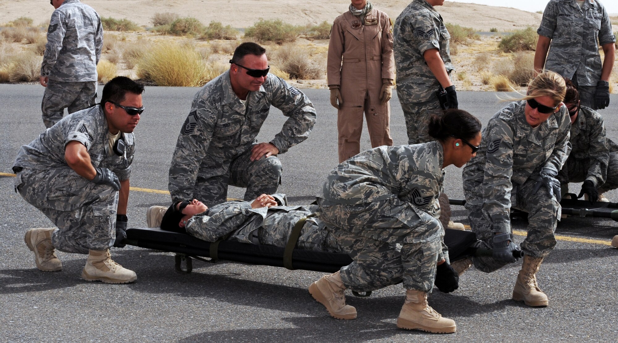 386th Expeditionary Medical Group members prepare to lift a simulated patient to a U.S. Navy MH-60 Sierra helicopter July 22 as part of litter training conducted here for medics and non-medics alike. Joint training with the U.S. Navy helped the Airmen communicate with each other using hand gestures and signals. (U.S. Air Force photo by Senior Airman Laura Turner)