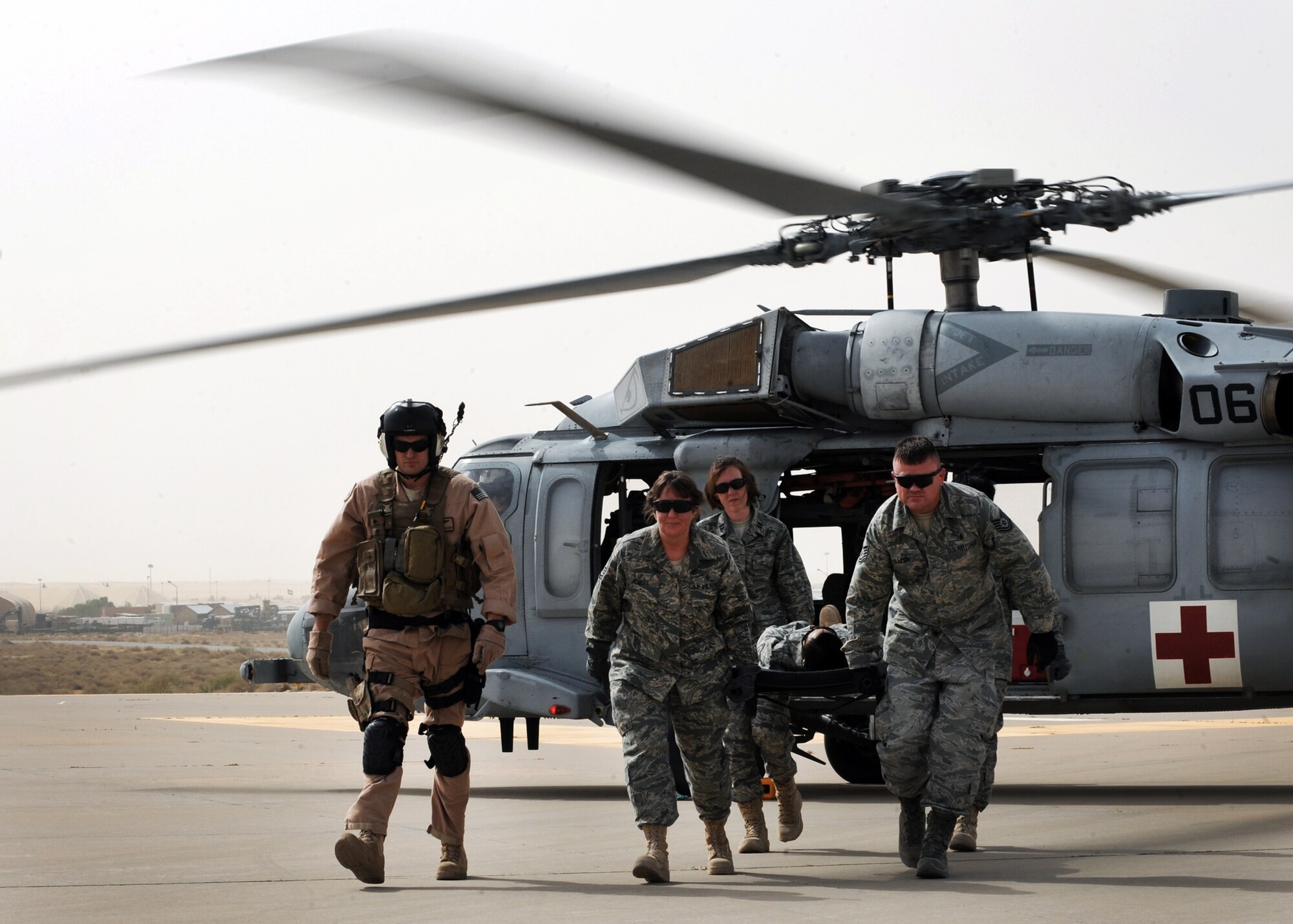 Members of the 386th Expeditionary Medical Group transfer patients to and from a U.S. Navy MH-60 Sierra helicopter here July 22 as part of helo-interface refresher training. The joint training on loading and extraction techniques benefitted medics as well as other medical group Airmen who do not routinely handle patients on a day-to-day basis. (U.S. Air Force photo by Senior Airman Laura Turner)