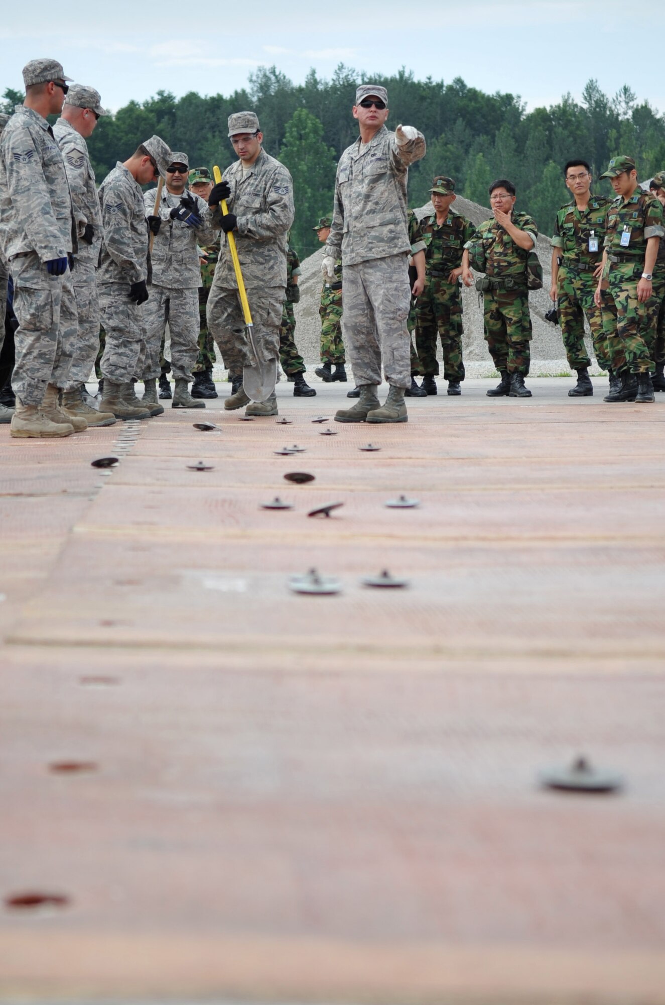 Members of the 51st Civil Engineer Squadron lay out a fiberglass mat at Jungwon AB, Republic of Korea July 29 during the 2010 Combined Airfield Repair Exercise. The mats are used to quickly repair runway damage, and can be connected to cover larger areas.  (U.S. Air Force Photo/Senior Airman Evelyn Chavez)