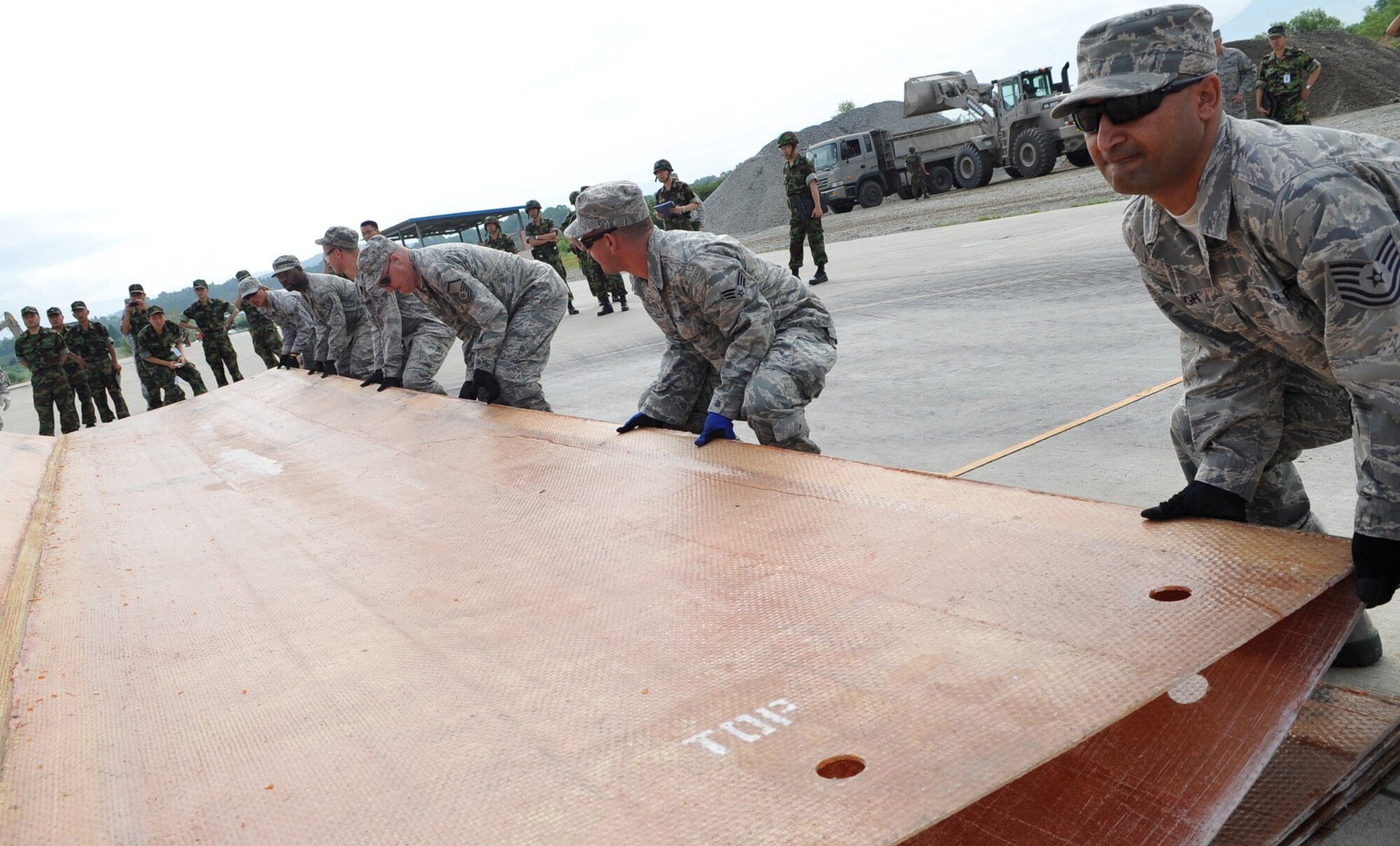 Tech. Sergeant Yuvraj Singh, 51st Civil Engineer Squadron, helps unfold a fiberglass mat during the 2010 Combined Airfield Repair Exercise at Jungwon AB, July 29.  The purpose of the exercise was to enhance interoperability, evaluate capabilities, and strengthen combined relationships with Republic of Korea Air Force members. (U.S. Air Force Photo/Senior Airman Evelyn Chavez)