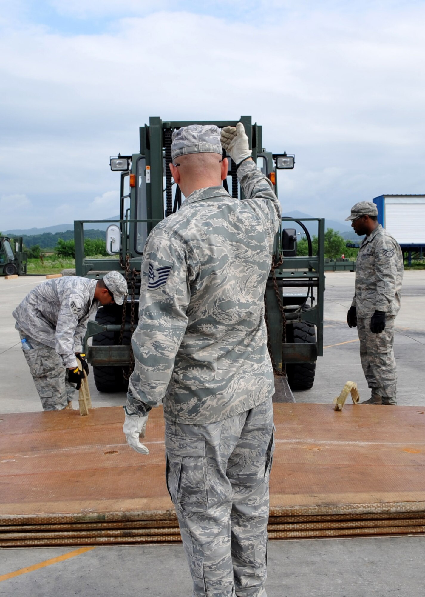 Members of the 51st Civil Engineer Squadron help lift a fiberglass mat during the 2010 Combined Airfield Repair Exercise at Jungwon AB, July 29.  The purpose of the exercise took was to enhance interoperablitiy, evaluate capabilities, and strengthen combined relationships.  (U.S. Air Force Photo/Senior Airman Evelyn Chavez)