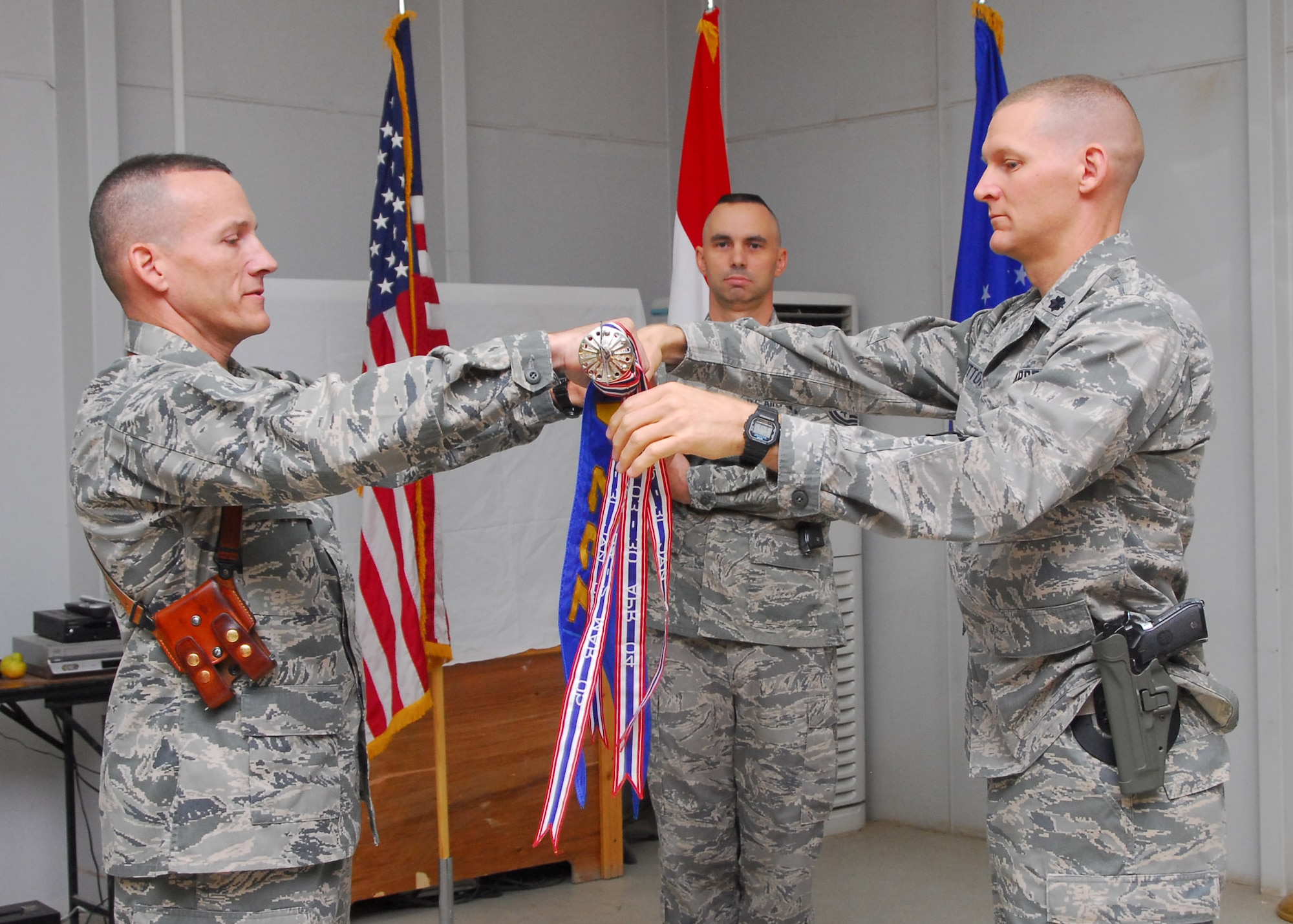 Col. David Marttala, 732nd Air Expeditionary Group commander, and Lt. Col. Dustin Sutton, 732nd Expeditionary Security Forces Squadron commander, furl the guide on for the casing of colors ceremony July 31, 2010, Joint Base Balad, Iraq.  When a military unit is inactivated, it's tradition to hold a casing of the colors ceremony, which includes reading the command's history, before casing the unit’s distinctive flag, or “colors,” in a protective sheath. (U.S. Air Force photo/Senior Airman Marianne E. Lane)
