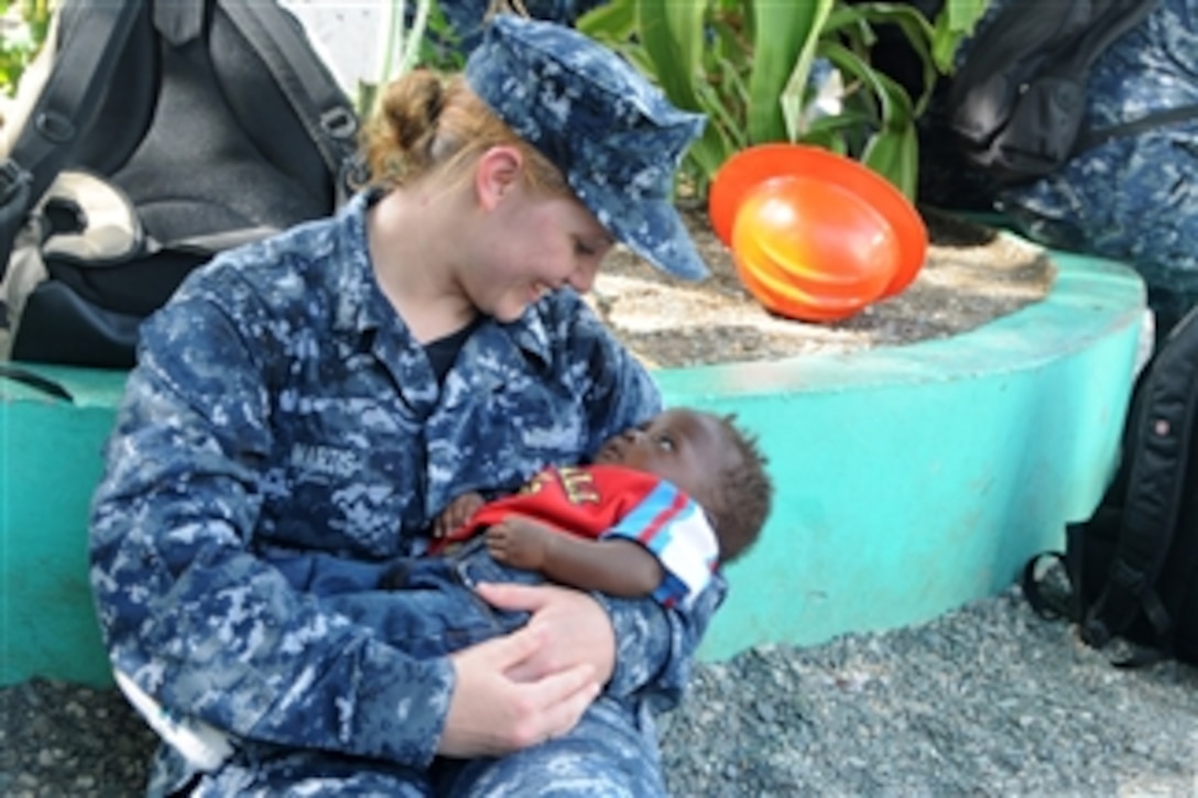 U.S. Navy Yeoman 2nd Class Rachel Martis, assigned to the amphibious assault ship USS Iwo Jima (LHD 7), cradles a Haitian child during a community service project at the Northwest Haiti Christian Mission in Port de Paix, Haiti, on July 27, 2010.  The Iwo Jima is supporting Continuing Promise 2010, the fifth in a series of U.S. Pacific Fleet humanitarian deployments conducted in Latin America and the Caribbean aimed at strengthening regional partnerships.  DoD photo by Petty Officer 2nd Class Zane Ecklund, U.S. Navy.  (Released)