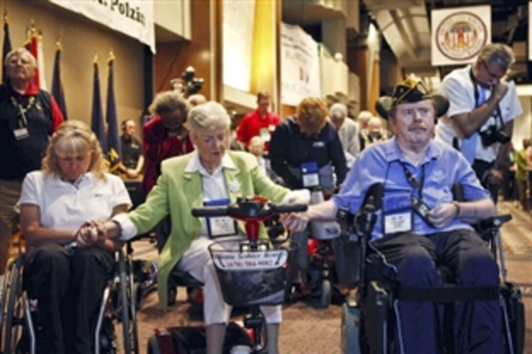Delegates hold hands during a prayer at the Disabled American Veterans 89th National Convention in Atlanta, Aug. 2, 2010. President Barack Obama addressed the group and spoke about the ongoing drawdown in Iraq, support for U.S. troops in Iraq and Afghanistan, and the administration’s commitment to serve veterans.