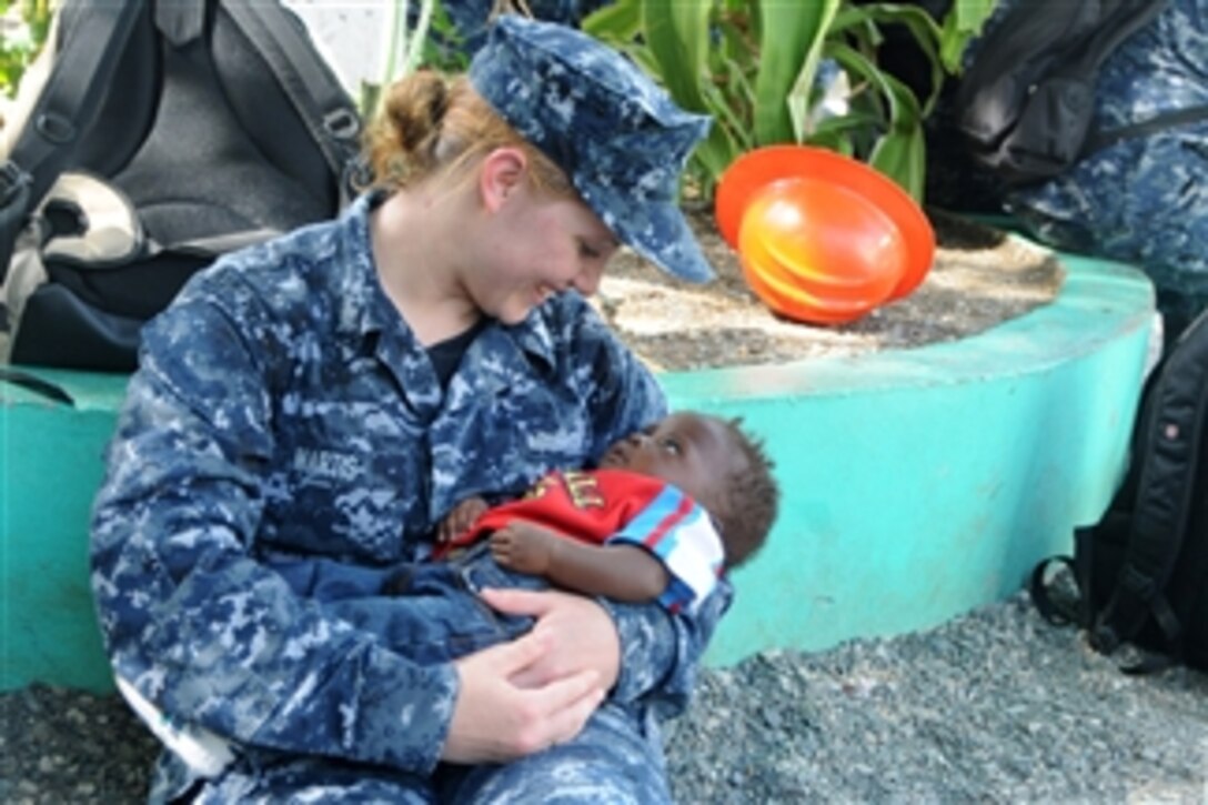 U.S. Navy Yeoman 2nd Class Rachel Martis, assigned to the amphibious assault ship USS Iwo Jima (LHD 7), cradles a Haitian child during a community service project at the Northwest Haiti Christian Mission in Port de Paix, Haiti, on July 27, 2010.  The Iwo Jima is supporting Continuing Promise 2010, the fifth in a series of U.S. Pacific Fleet humanitarian deployments conducted in Latin America and the Caribbean aimed at strengthening regional partnerships.  DoD photo by Petty Officer 2nd Class Zane Ecklund, U.S. Navy.  (Released)
