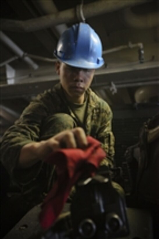 A U.S. Marine Corps corporal with the 4th Platoon, Charlie Company, 3rd Assault Amphibian Battalion, 1st Marine Division cleans a .50-caliber machine gun on top of an amphibious assault vehicle in the well deck of the amphibious transport dock ship USS New Orleans (LPD 18) in Peru on July 26, 2010.  The unit is deployed in support of operation Partnership of the Americas/Southern Exchange, a combined amphibious exercise to enhance cooperative partnerships with maritime forces from Argentina, Mexico, Peru, Brazil, Uruguay and Colombia.  