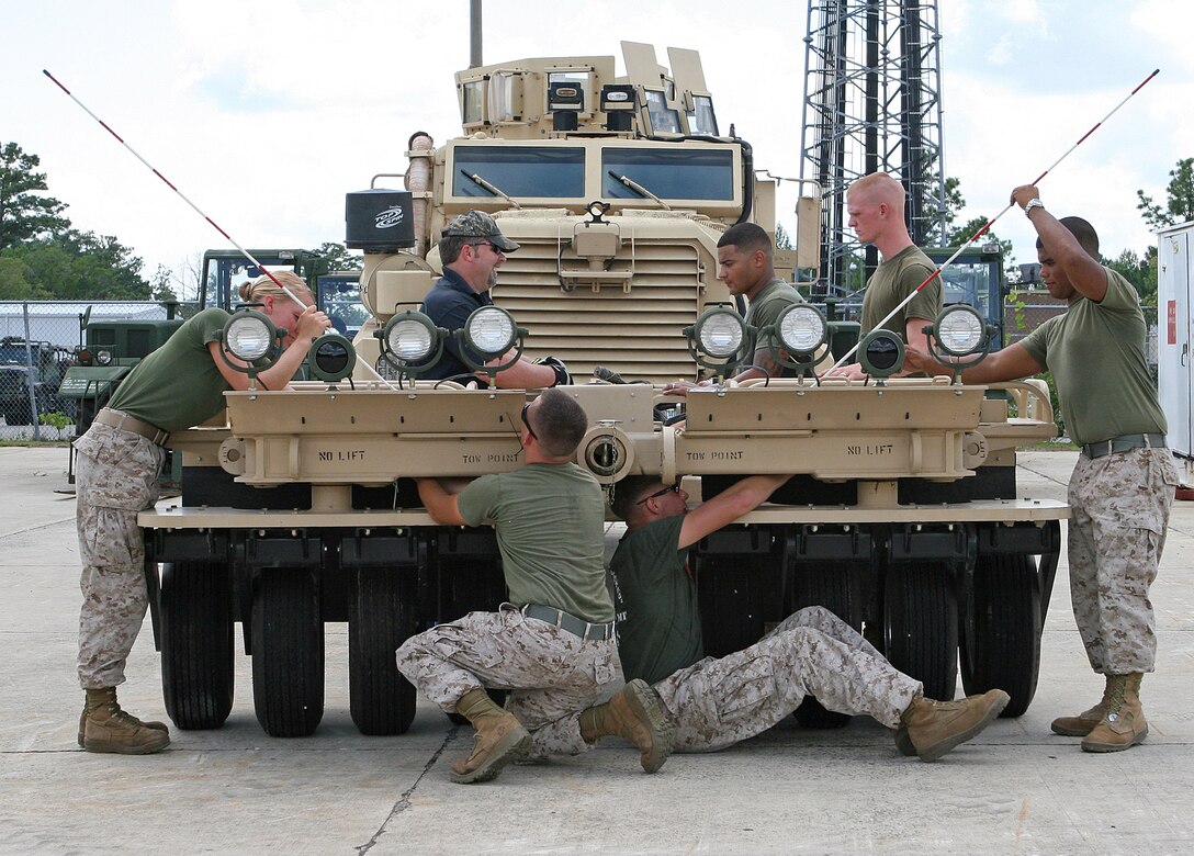 Marines from various stations on the East Coast work as a team to maintain a Panama City Generation III Mine Roller System attached to a Mine Resistant Ambush Protected tactical vehicle aboard Marine Corps Base Camp Lejeune, N.C., Aug. 2, 2010. The Marines took part in a three-day training evolution to learn how to maintain and operate the newly upgraded mine roller system that is currently being employed by the Marine Corps in Afghanistan.