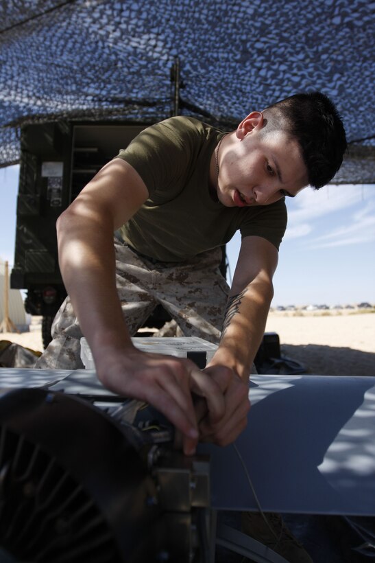 Corporal Anthony Cuevas, an unmanned aerial vehicle technician with Marine Unmanned Aerial Vehicle Squadron 3, helps break down an RQ-7B UAV Aug. 3 at the Combat Center's Expeditionary Air Field. The squadron is currently supporting Enhanced Mojave Viper.