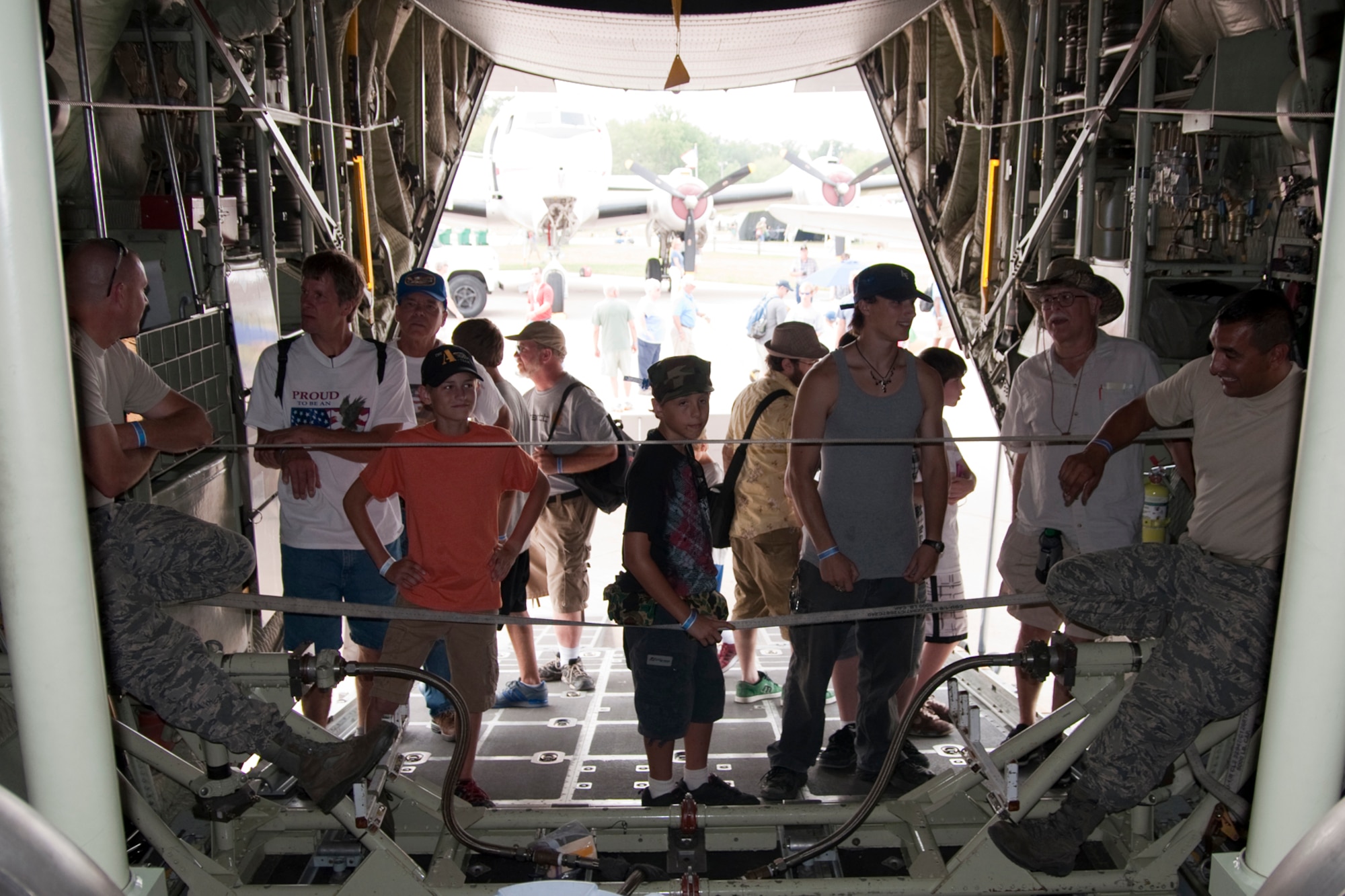 OSHKOSH, Wis. --  Tech. Sgt. Thomas Kocis and Tech. Sgt. Stephen Feliz, both aerospace maintenance specialists with the 910th Aircraft Maintenance Squadron based at Youngstown Air Reserve Station, Ohio, talk with AirVenture 2010 air show visitors inside of a YARS specially-equipped aerial spray C-130H at Wittman Regional Airport here, July 30, 2010. This aircraft and approximately 14 YARS Airmen were invited to particpate in this air show because of their recent involvement in the Gulf oil spill relief efforts. The 910th AW is home to the Department of Defense's only large area fixed-wing aerial spray mission. U.S. Air Force photo by Senior Airman Brenda Haines