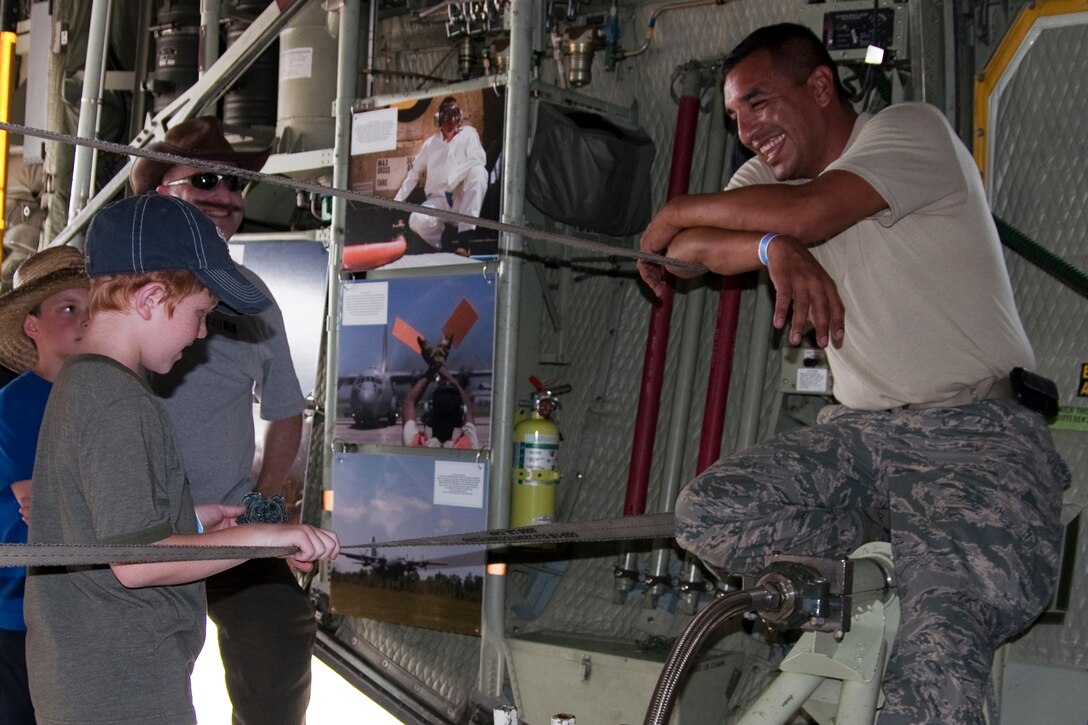 OSHKOSH, Wis. --  Tech. Sgt. Stephen Feliz, an aerospace maintenance specialist with the 910th Aircraft Maintenance Squadron based at Youngstown Air Reserve Station, Ohio, gives an Air Mobility Command patch to a young AirVenture 2010 air show visitor inside of a YARS specially-equipped aerial spray C-130H at Wittman Regional Airport here, July 30, 2010. This aircraft and approximately 14 YARS Airmen were invited to particpate in this air show because of their recent involvement in the Gulf oil spill relief efforts. The 910th AW is home to the Department of Defense's only large area fixed-wing aerial spray mission. U.S. Air Force photo by Senior Airman Brenda Haines