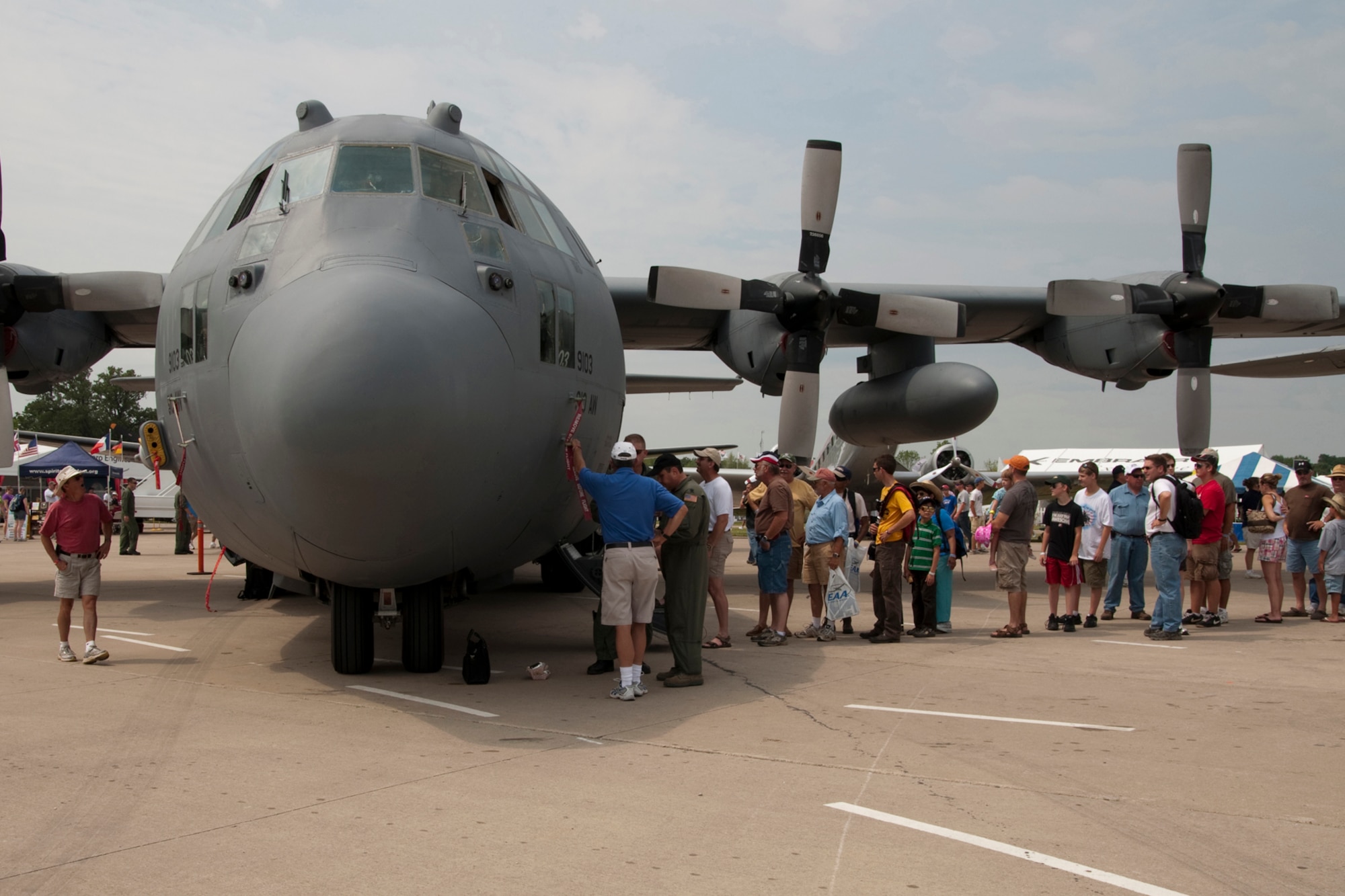 OSHKOSH, Wis. -- AirVenture 2010 air show spectators wait in line to examine a U.S. Air Force specially-equipped aerial spray C-130H aircraft from the 910th Airift Wing based at Youngstown Air Reserve Station, Ohio, while it is on display at Wittman Regional Airport here, July 30, 2010. This aircraft and approximately 14 YARS Airmen were invited to particpate in this air show because of their recent involvement in the Gulf oil spill relief efforts. The 910th AW is home to the Department of Defense's only large area fixed-wing aerial spray mission. U.S. Air Force photo by Senior Airman Brenda Haines