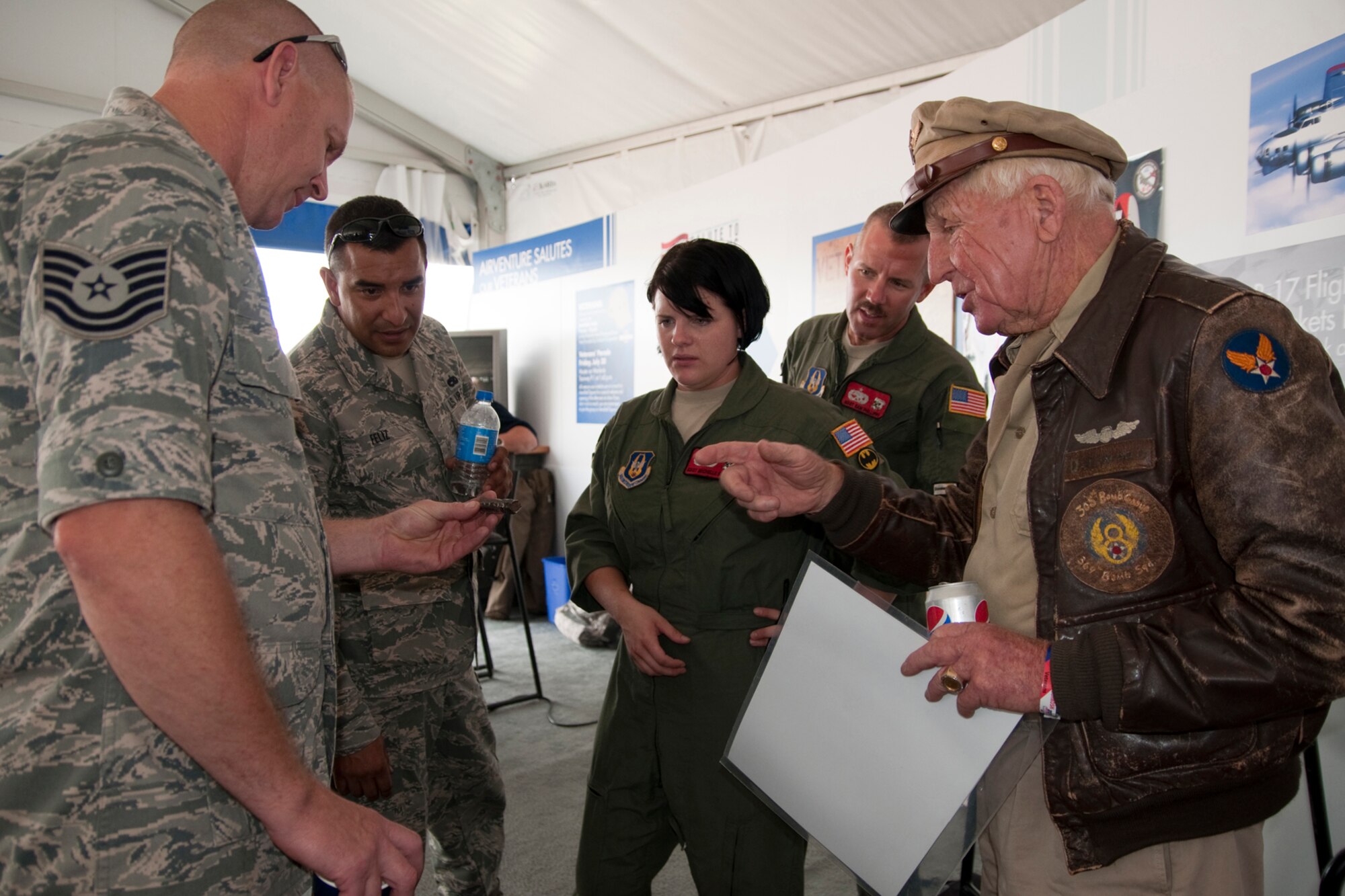 OSHKOSH, Wis. -- A group of U.S. Air Force Reservists from the 910th Airift Wing based at Youngstown Air Reserve Station, Ohio, talk to a World War II veteran during AirVenture 2010 at Wittman Regional Airport here, July 30, 2010. Approximately 14 YARS Airmen and one specially-equipped aerial spray C-130H were invited to particpate in this air show because of their recent involvement in the Gulf oil spill relief efforts. The 910th AW is home to the Department of Defense's only large area fixed-wing aerial spray mission. U.S. Air Force photo by Senior Airman Brenda Haines
