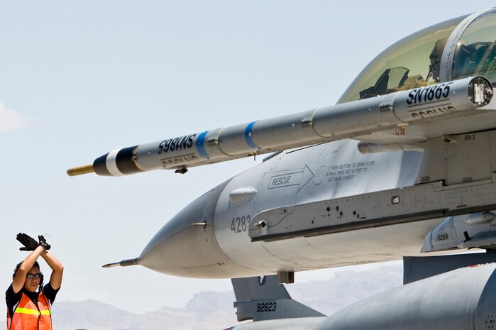 NELLIS AIR FORCE BASE, Nev. -- A Republic of Singapore Air Force crew chief uses hand signals to direct an F-16CG pilot to stop on the Nellis flight line, July 29, 2010 during Red Flag 10-4. The RSAF is stationed at Luke AFB, pilots and maintenance personnel are assigned to the 425th for two years, during which they receive advanced tactics training by participating in Red Flag exercises. (U.S. Air Force photo/Lawrence Crespo) 