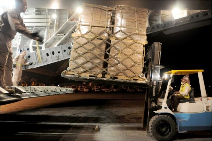Airman First Class Christian Ruhe and Staff Sgt. Manuel Chacon guide Javed Iqbal, a Peshawar International Airport ramp supervisor, as he backs a pallet of halal meals out of a C-17 Globemaster III Aug. 2, 2010, in Peshawar, Pakistan. Airman Ruhe and Sergeant Chacon are both loadmasters assigned to the 817th Expeditionary Airlift Squadron at the Transit Center at Manas, Kyrgyzstan. (U.S. Air Force photo/Capt. Chris Sukach)