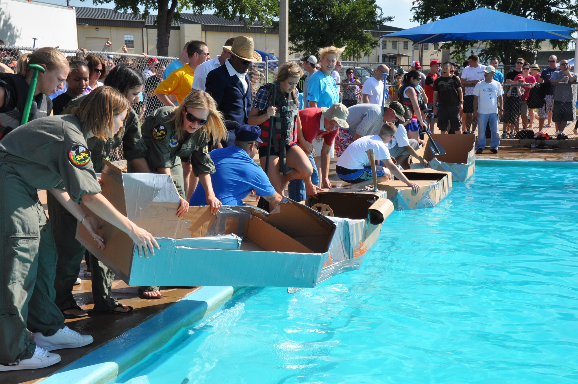 Teams in the 10th annual Build-a-Boat Race at the Bunker Hill Pool put their cardboard boats in the pool and the team captains begin climbing aboard, at Sheppard Air Force Base, Texas, July 31. The boats and teams were judged in six different categories including: The Barracuda, fastest time; The Jewel of the Pool, the best decorated boat; The Ugly Duckling, the least decorated boat; the Commander’s Choice, the overall winner determined by the judges; The Rock, fastest sinking; and The Chipper Clipper, most enthusiastic team. (U.S. Air Force photo/Airman 1st Class Adawn Kelsey)