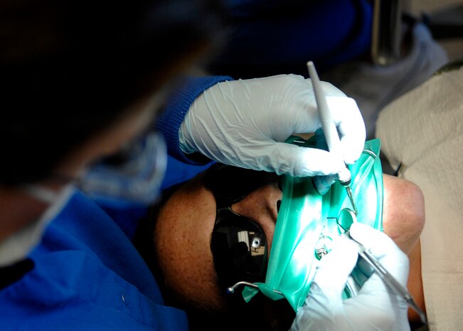 Maj. Courtney Schapira carves and shapes a patient's filling using an interproximal carver at the Deily Dental Clinic June 8, 2010, on Joint Base Charleston, S.C. A rubber dam was used during the procedure to isolate the tooth, keeping it separated from other teeth and preventing debris from being swallowed. Major Schapira is a general dentist with the 628th Medical Group. (U.S. Air Force photo/Senior Airman Timothy Taylor)