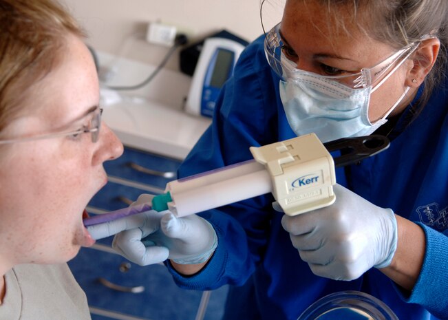 Kathy Dietrich takes a bite registration from a patient using a paste called Regisil PB at the Deily Dental Clinic June 8, 2010, on Joint Base Charleston, S.C. Bite registrations are used to make night guards and essex retainers by showing technicians how a patient's teeth fit together. Mrs. Dietrich is a dental technician with the 628th Medical Group. (U.S. Air Force photo/Senior Airman Timothy Taylor)
