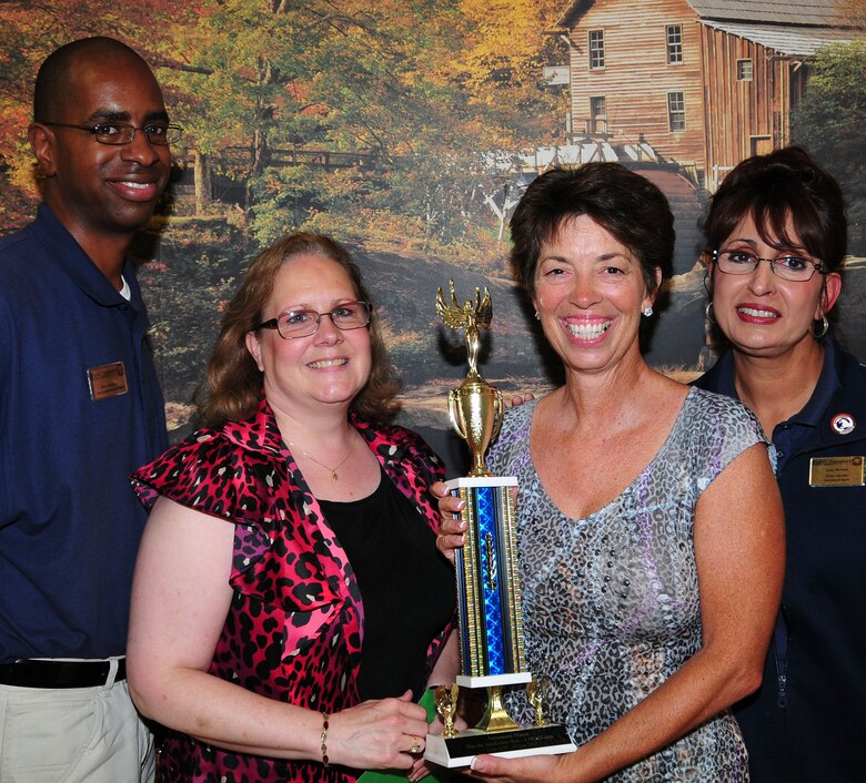 (L-R) Eric Catchings, Gayle Kenyon, Annamarie Mason and Lena Morneau celebrate Mason's achievement as winner of the “Hike the Appalachian Trail” competition at the Altus Fitness Center. She received a trophy and certificate August 3 for walking 3,790,970 steps during the last year, equaling 1,896 miles.(U.S. Air Force photo, Tech. Sgt. Jennifer D. Seidl / Released 97 Air Mobility Wing Public Affairs)