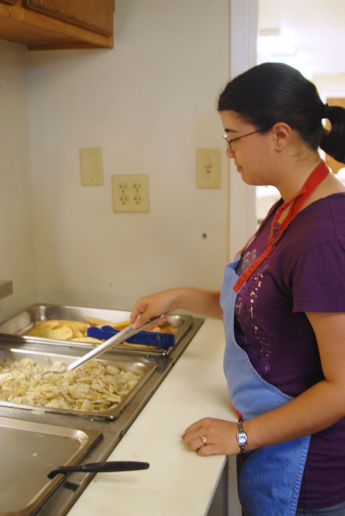 GOODFELLOW AIR FORCE BASE, Texas -- Airman 1st Class Kathryn Loustaunau, 17th Medical Support Squadron, prepares food at a soup kitchen, July 24. She and 18 other first term Airmen volunteered in the community as part of a First Term Airmen Center course assignment. FTAC is designed to help first termers transition from technical training to an operational environment and is a requirement for all Airmen upon arrival to their first duty station. (U.S. Air Force photo/ Airman 1st Class Jessica D. Keith)