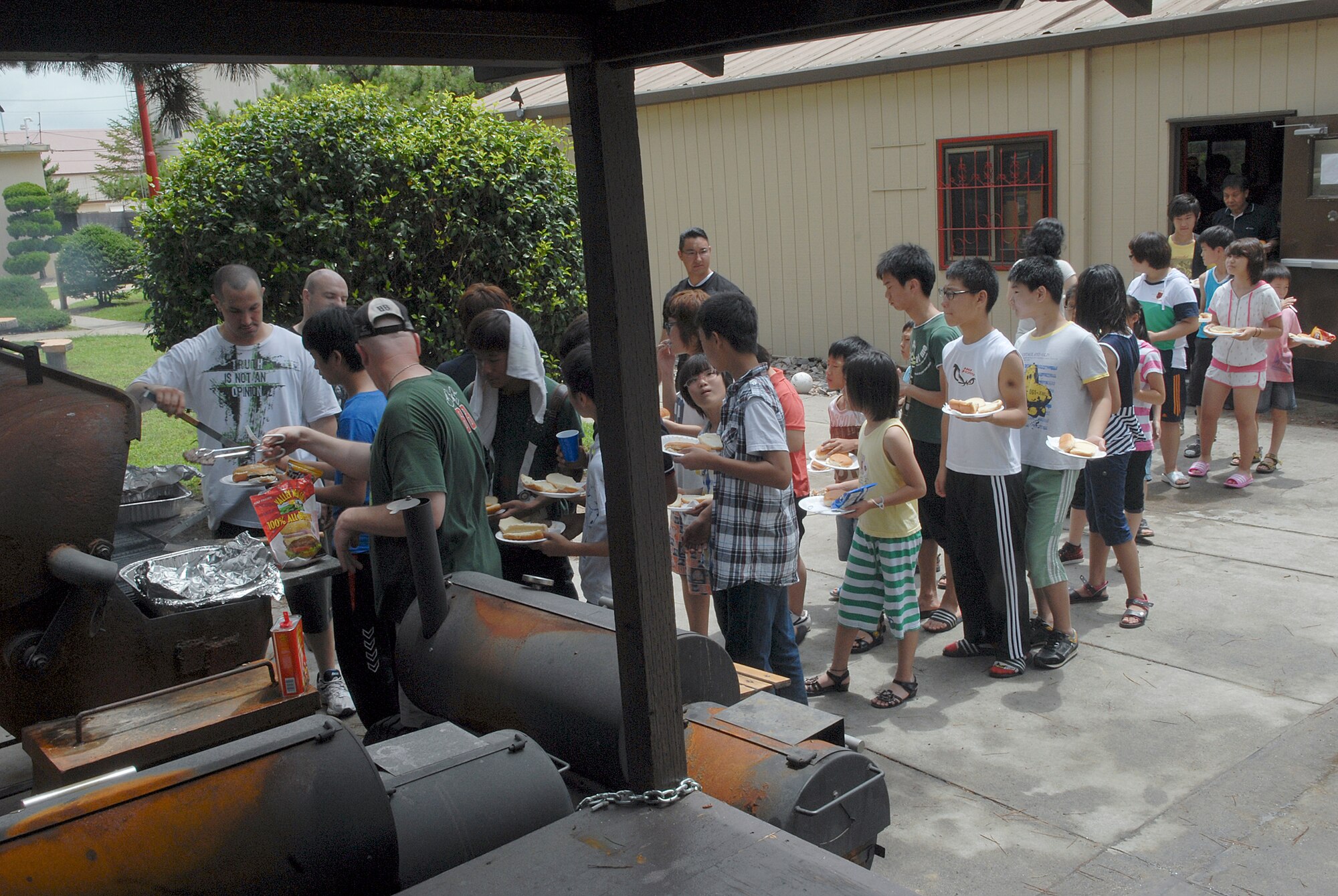 Volunteers serve hot dogs, hamburgers and chicken legs to children from the Il Mag Won Orphanage during a kid's day July 24, 2010, at Kunsan Air Base, South Korea. (U.S. Air Force photo/Senior Airman Roy Lynch)