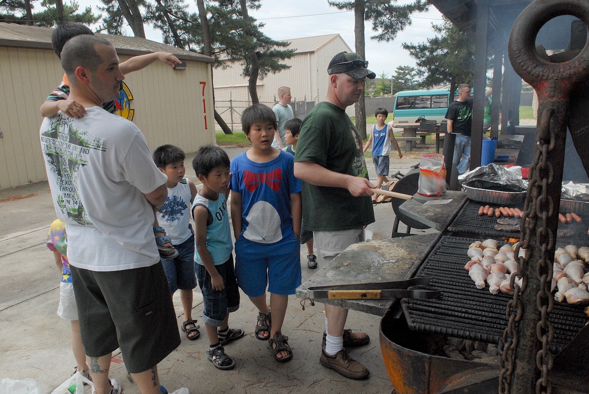 Children from the Il Mag Won Orphanage watch as volunteers prepare hot dogs, hamburgers and chicken legs during a kid's day July 24, 2010, at Kunsan Air Base, South Korea. (U.S. Air Force photo/Senior Airman Roy Lynch)