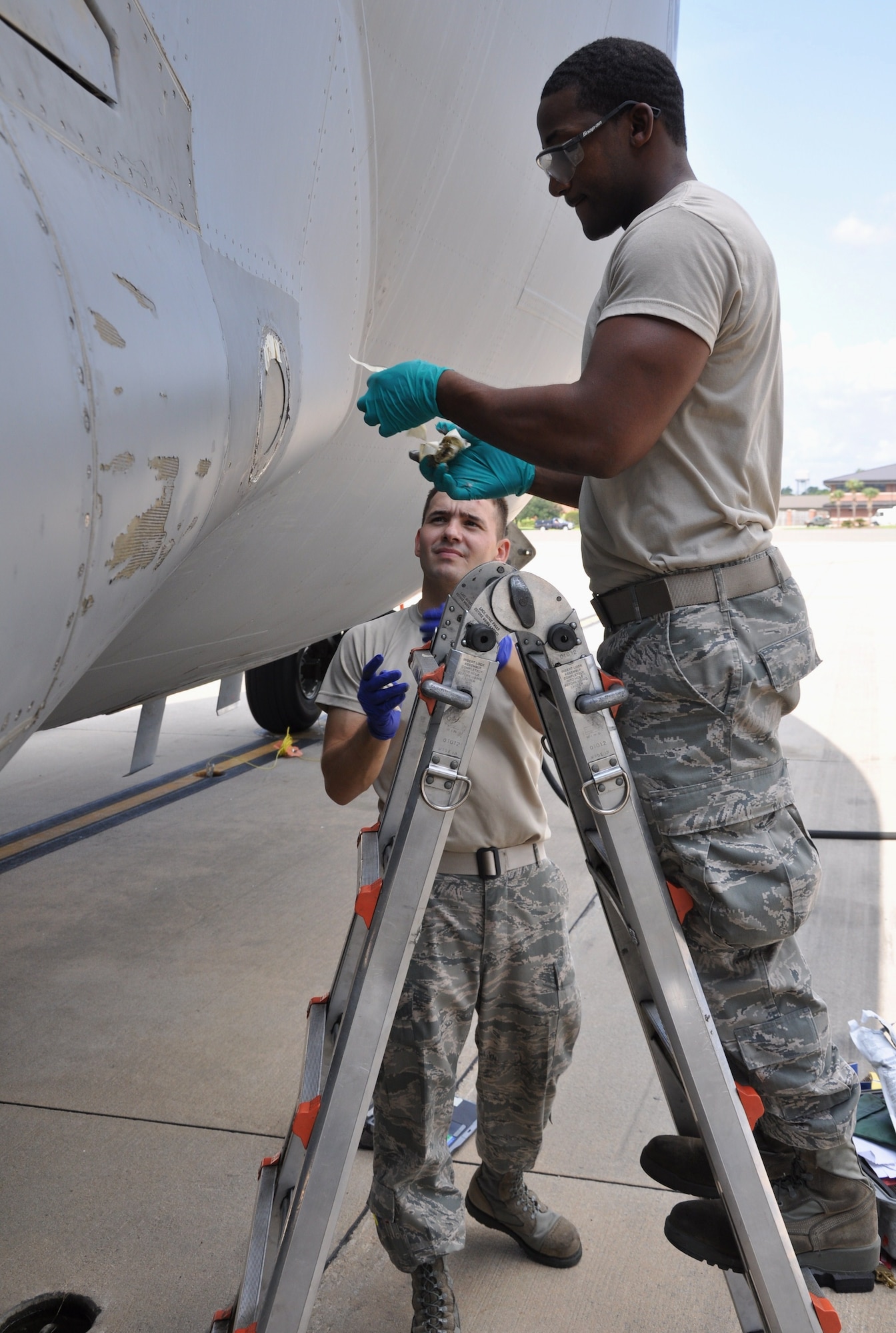 Senior Airman Steven A. Brown and Airman 1st Class Daniel N. Torrio remove tape from around a taxi light on a C-17 Globemaster III Aug. 3, 2010, at Charleston Air Force Base, S.C. Airman Brown is a crew chief with the 315th Aircraft Maintenance Squadron here and Airman Torrio is a crew chief with the 437th Aircraft Maintenance Squadron here. (U.S. Air Force photo/Staff Sgt. Shane Ellis)