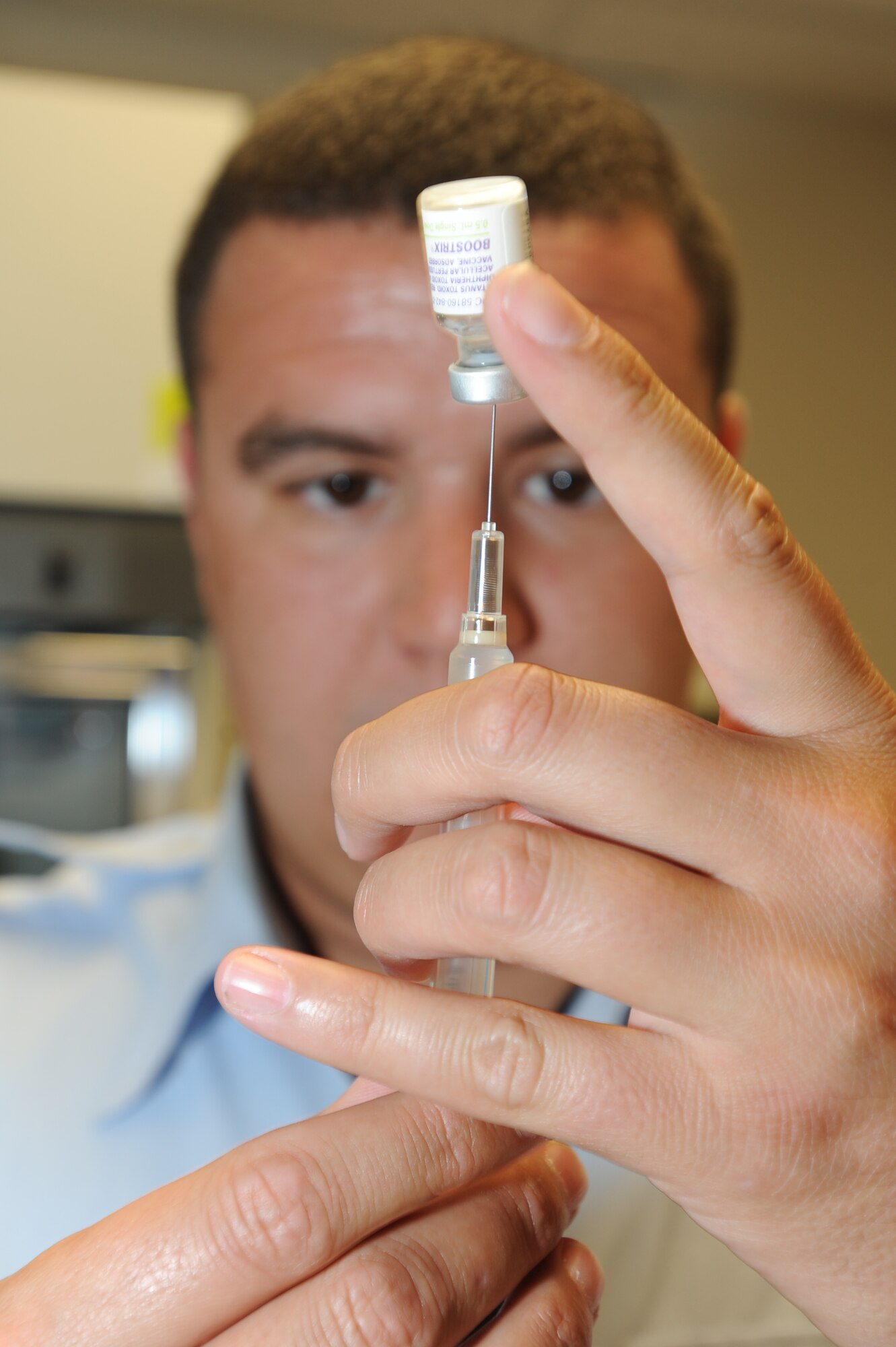 WHITEMAN AIR FORCE BASE, Mo. - Staff Sgt. Adam Whiffen, 509th Medical Operation Squadron immunization clinic technician, draws up a shot for his next patient, Aug. 2.  With school starting, Sgt. Whiffen suggests all parents make sure their children are up-to-date with their shots to help prevent illness. For more information, or to make an appointment, contact the immunization clinic at (660) 687-4304.(U.S. Air Force photo by Senior Airman Carlin Leslie)
