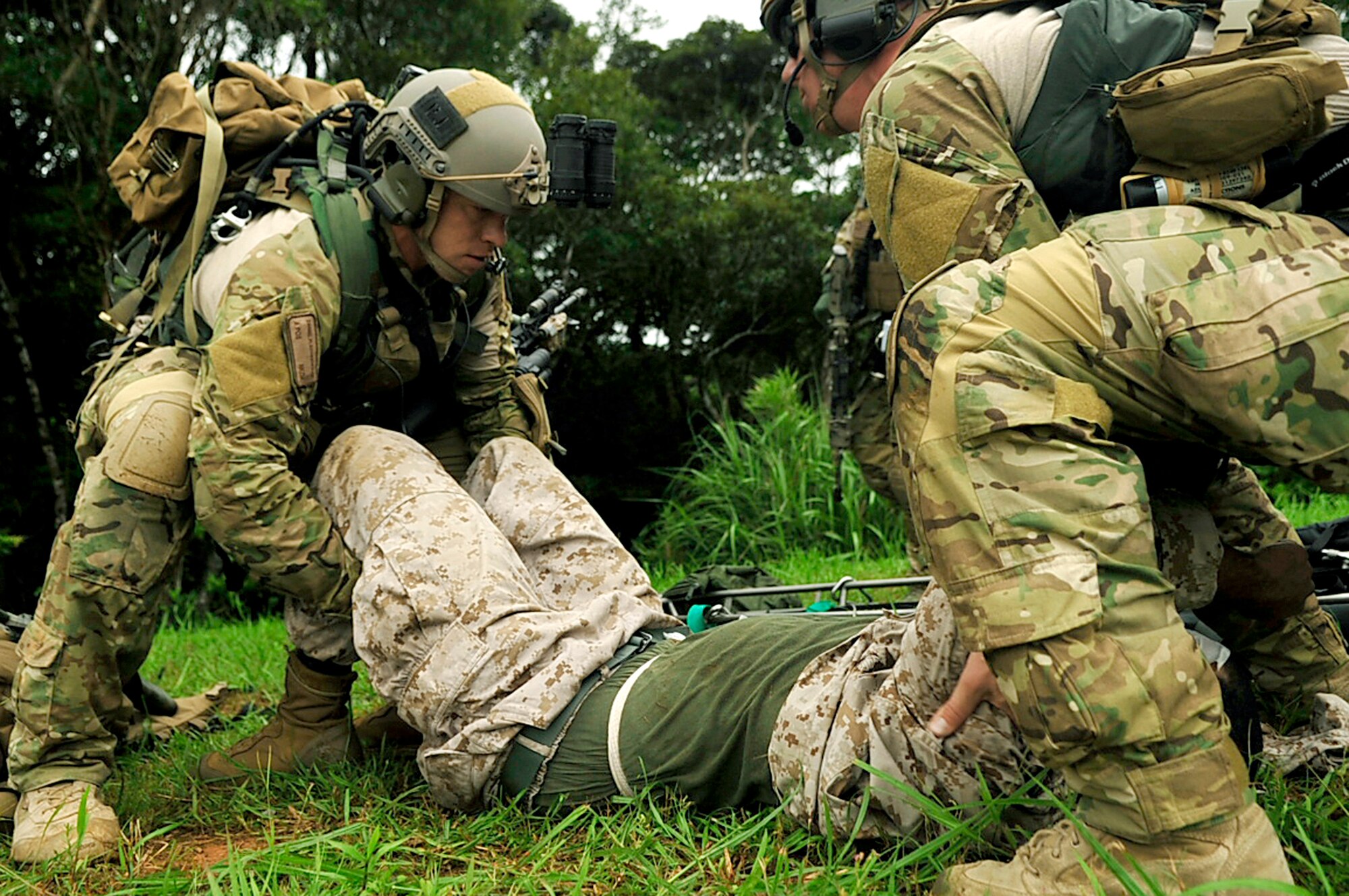 Senior Airmen Daniel Flechsenhaar (left) and Andrew Nichols move a simulated wounded Marine on to a litter during a joint combat training exercise July 28, 2010, at Kadena Air Base, Japan. The Airmen are pararescuemen from the 31st and 33rd Rescue Squadrons. (U.S. Air Force photo/Senior Airman Amanda N. Grabiec)
