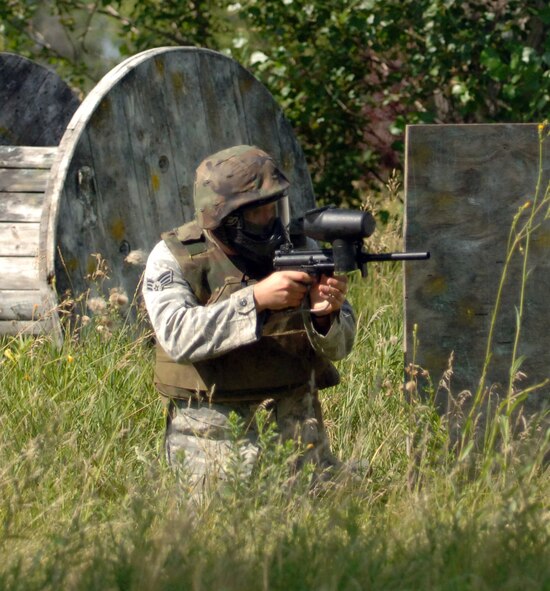 Senior Airman Aaron Smith, 319th Security Forces Squadron installation entry controller, provides cover fire for his teammate during a game of capture the flag, part of the annual combat readiness training Aug. 2 at the Grand Forks Air Force Base paintball course. The mandatory training included a refresher course in evasive maneuvers and tactical movement, and culminated in a demonstration of skills during a game of paintball. (U.S. Air Force photo by Airman 1st Class Rachel Martinez)