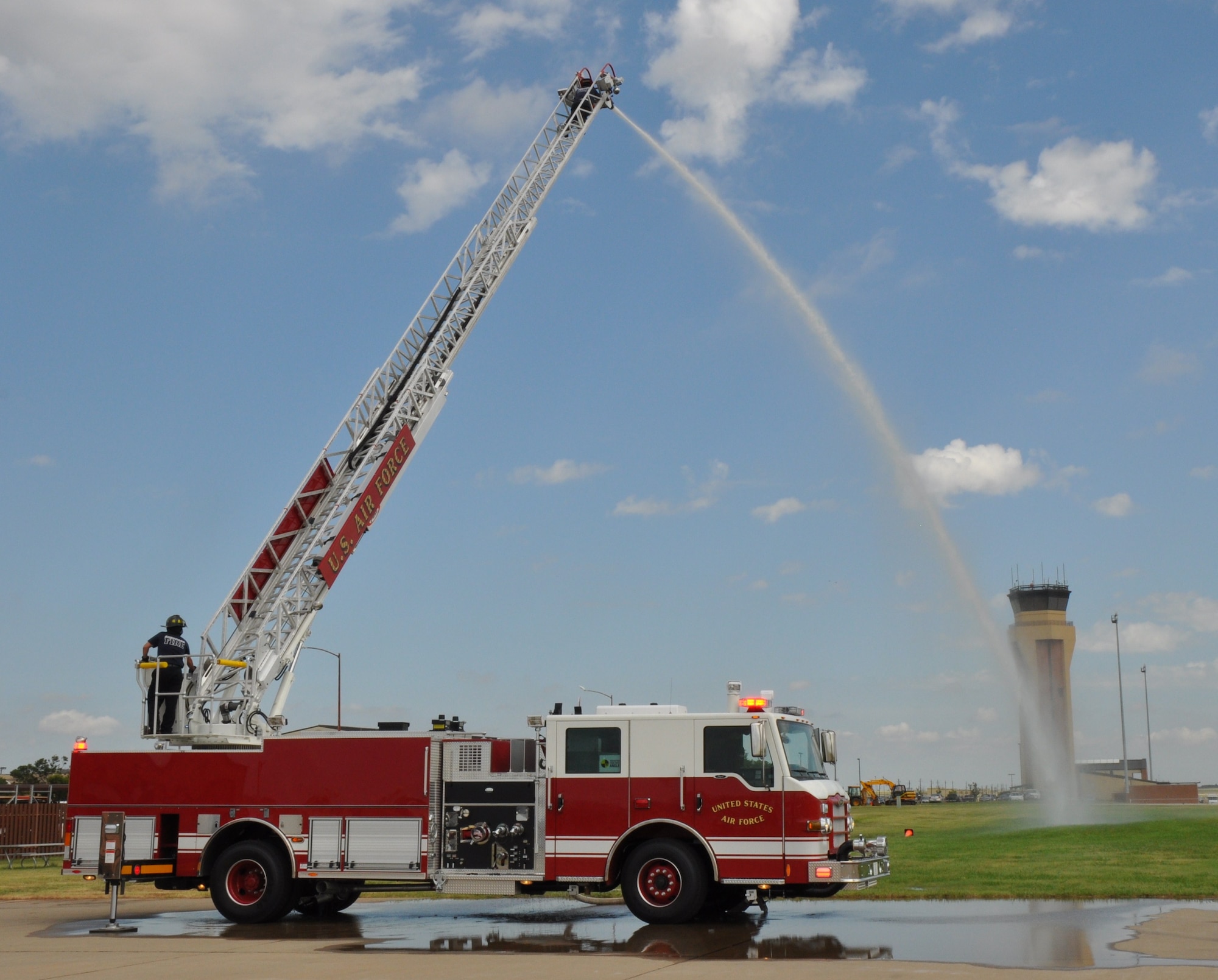 Sheppard fire fighter Justin Kennedy (bottom), operates the 75-foot ladder of the new fire truck as Juan Dominguez, Sheppard Fire Department lead fire fighter, operates the elevated water stream from the top of the ladder, July 28 near the fire house at Sheppard Air Force Base, Texas. The Sheppard Fire Department received the truck through the Air Force Firefighting Vehicle Modernization Program. (U.S. Air Force photo/Airman 1st Class Adawn Kelsey)