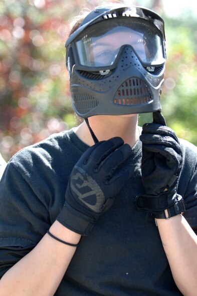 Airman 1st Class Amber Murphy, 319th Security Forces Squadron installation entry controller, clips a protective mask into place before participating in the annual combat readiness training Aug. 2 at the Grand Forks Air Force Base paintball course. The mandatory training included a refresher course in evasive maneuvers and tactical movement, and culminated in a demonstration of skills during a game of paintball. (U.S. Air Force photo by Airman 1st Class Rachel Martinez)
