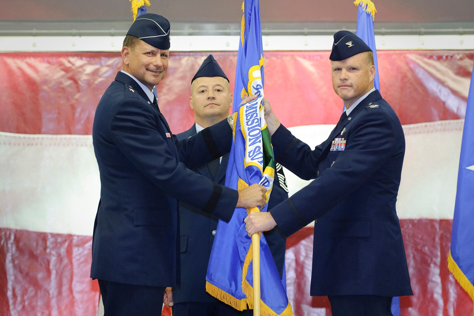 Brig. Gen. Leonard Patrick, 502nd Air Base Wing commander, passes the group guidon to Col. Scott Peel, incoming 902nd Mission Support Group commander, during a change of command ceremony held in hangar four at Randolph Air Force Base, Texas August 2. (U.S. Air Force photo/Steve Thurow)