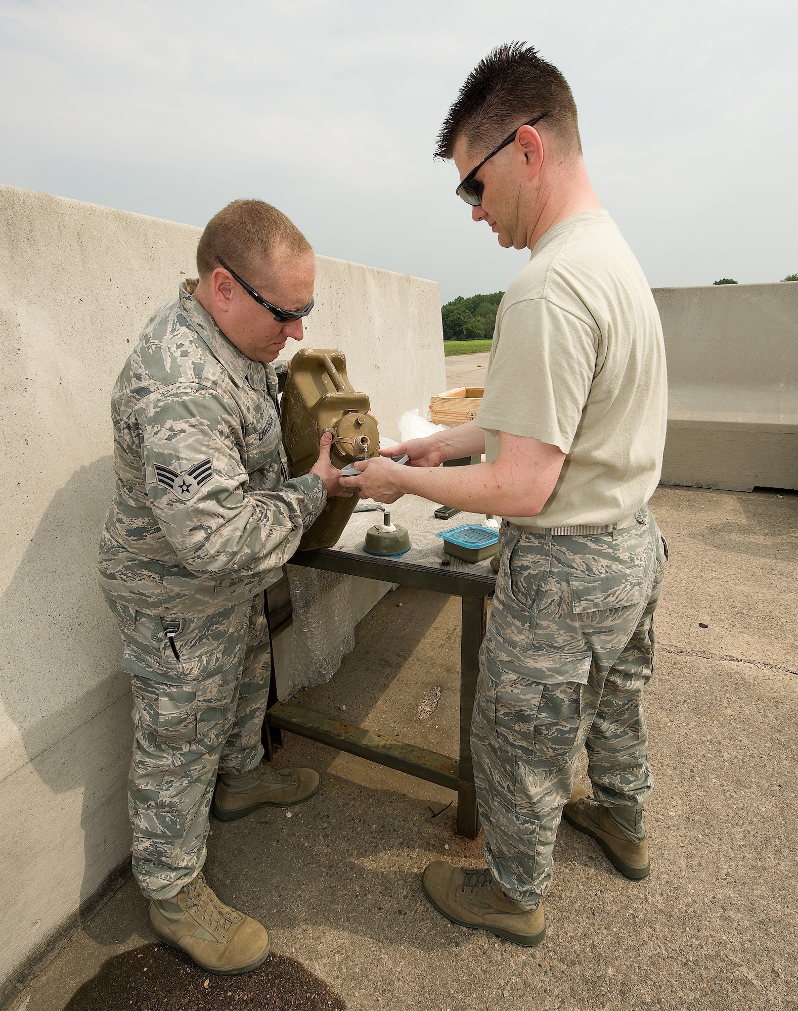 Senior Airman John Larosch, (left), 512th Civil Engineer Squadron Explosive Ordnance Disposal Flight technician fills a water charge with Staff Sgt. Christopher Erickson, 512th EOD technician, at the EOD range, July 29. The technicians were testing different theories of demolition as part of their training. Sergeant Erickson and Airman Larosch are two of seven reservists assigned to the 512th EOD Flight, Dover Air Force Base, Del. (U.S. Air Force photo/Jason Minto)