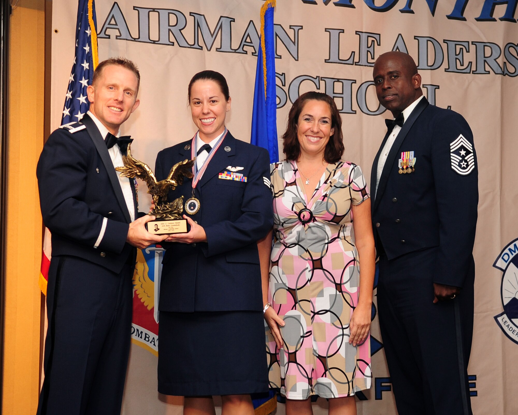 Senior Airman Anna Levanduski (center) of the 755th Operations Support Squadron poses with Col. John Cherrey (left), 355th Fighter Wing commander, Chief Master Sgt. Vincent Howard, 355th Fighter Wing command chief, and Ellen Jimenez, president of the Military Affairs Committee, after being presented with the John L. Levitow Award at the Airmen Leadership School graduation ceremony for Class 10-G at the Mirage Club here July 29, 2010. Thirty-seven enlisted members graduated from Davis-Monthan's Airmen Leadership School, which prepares senior airmen for supervisory duties and fosters a commitment to the profession of arms. The Levitow award is the highest honor awarded during enlisted professional military education to the student who is most outstanding in performance evaluations, demonstrated leadership and teamwork. (U.S. Air Force photo/Airman 1st Class Jerilyn Quintanilla)