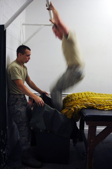 BARKSDALE AIR FORCE BASE, La. -- Airmen from the 2d Operational Support Squadron pack a drag-chute July 29. Some of AFE technician duties include inspecting, maintaining and adjusting aircrew life support and chemical defense equipment such as flight helmets, oxygen masks, survival kits, night-vision systems, parachutes, anti-gravity suits and other types of aircrew life support and chemical defense systems.  (U.S. Air Force photo by Senior Airman Brittany Y. Bateman)(RELEASED) 