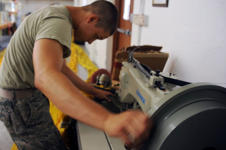 BARKSDALE AIR FORCE BASE, La. -- Airman 1st Class James Berg, 2d Operational Support Squadron, aircrew flight equipment technician, repairs a drag-chute July 29. Each B-52 has 11 parachutes and 10 survival kits. (U.S. Air Force photo by Senior Airman Brittany Y. Bateman)(RELEASED) 