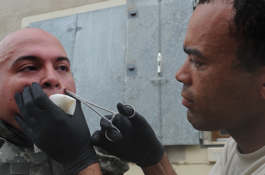 U.S. Army Spc. Gabriel Valverde, Bravo 14 Infantry, from Joint Multi-National Readiness Center Hohenfels, Germany, gets a simulated round removed by U.S. Air Force Master Sgt. Ronnie Wright, 435th Security Forces Squadron medic, Sembach Annex, Germany, during exercise ALLIED STRIKE 10, Hohenfels, Germany, Aug. 2, 2010. AS 10 is Europe's premier close air support (CAS) exercise, held annually to conduct robust, realistic CAS training that helps build partnership capacity among allied NATO nations and joint services while refining the latest operational CAS tactics. For more ALLIED STRIKE information go to www.usafe.af.mil/alliedstrike.asp. (U.S. Air Force photo by Senior Airman Caleb Pierce)