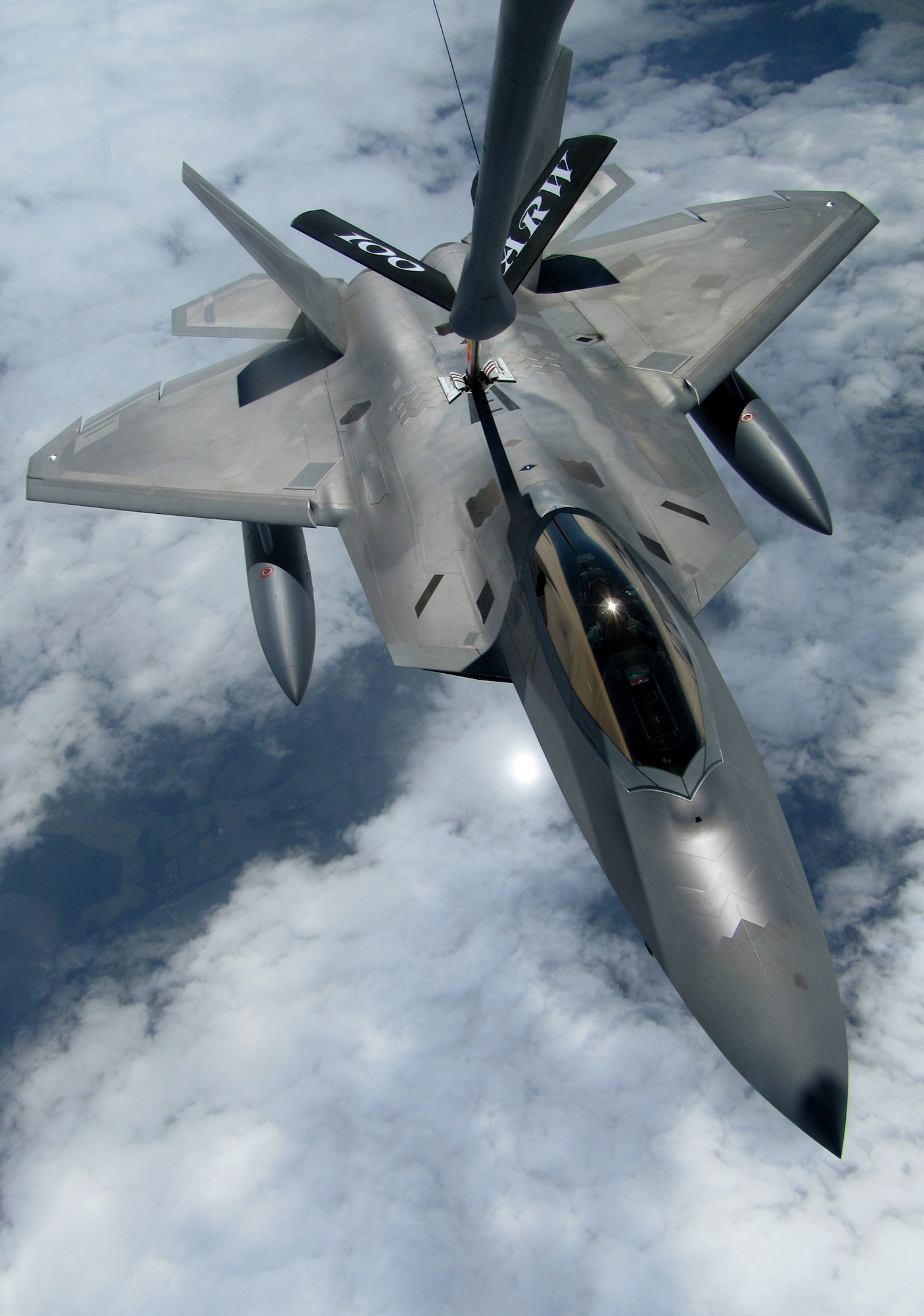 RAF MILDENHALL, England -- An F-22 Raptor from Elmendorf Air Force Base, Alaska, takes gas from a 100th Air Refueling Wing KC-135 Stratotanker July 27.  By flying with a tanker, the fighter could routinely fill its fuel tanks to ensure it had enough fuel to reach a safe base in the event it had to land.  (U.S. Air Force photo/Staff Sgt. Austin M. May)
