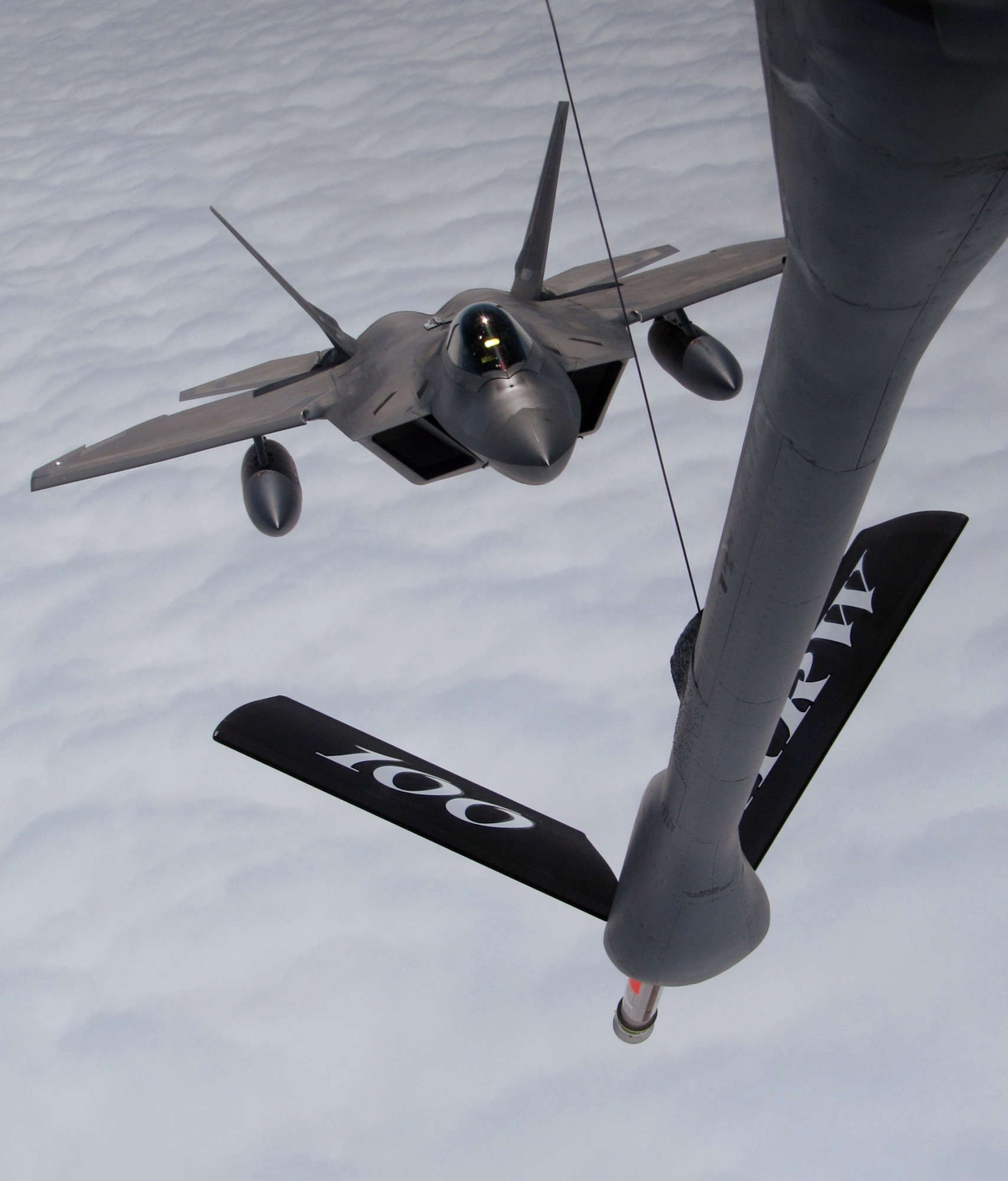 RAF MILDENHALL, England -- An F-22 Raptor from Elmendorf Air Force Base, Alaska, approaches the boom of a 100th Air Refueling Wing KC-135 Stratotanker July 27.  Part of a Coronet mission, the tanker took two F-22s halfway across the Atlantic Ocean before handing them off to another tanker for the rest of the journey.  (U.S. Air Force photo/Staff Sgt. Austin M. May)