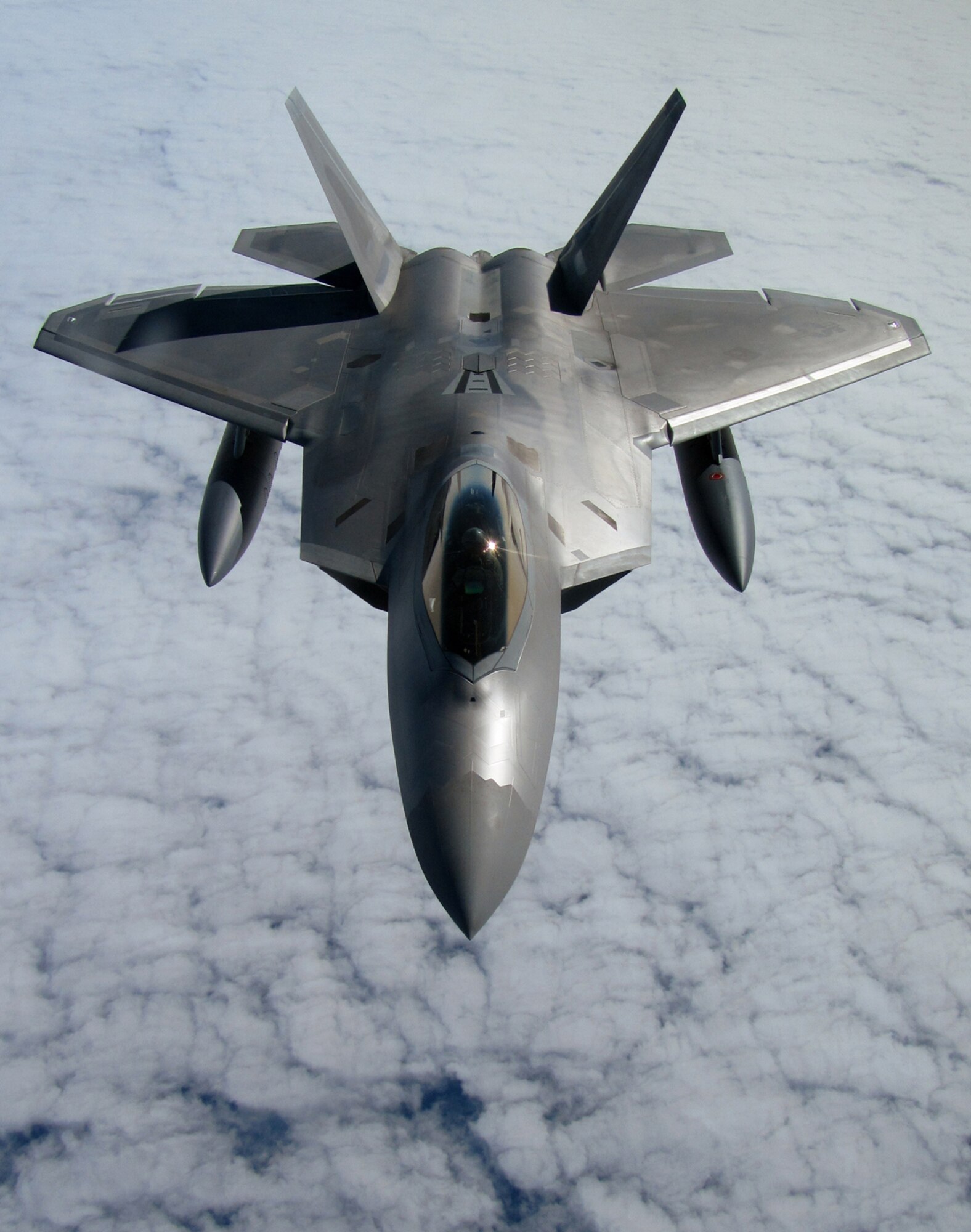 RAF MILDENHALL, England -- High above the Atlantic Ocean, an F-22 Raptor from Elmendorf Air Force Base, Alaska, trails a 100th Air Refueling Wing KC-135.  By sticking close to the tanker, the fighter could regularly top off its fuel tanks to ensure it had enough fuel to reach safety in the event it had to land unexpectedly.  (U.S. Air Force photo/Staff Sgt. Austin M. May)