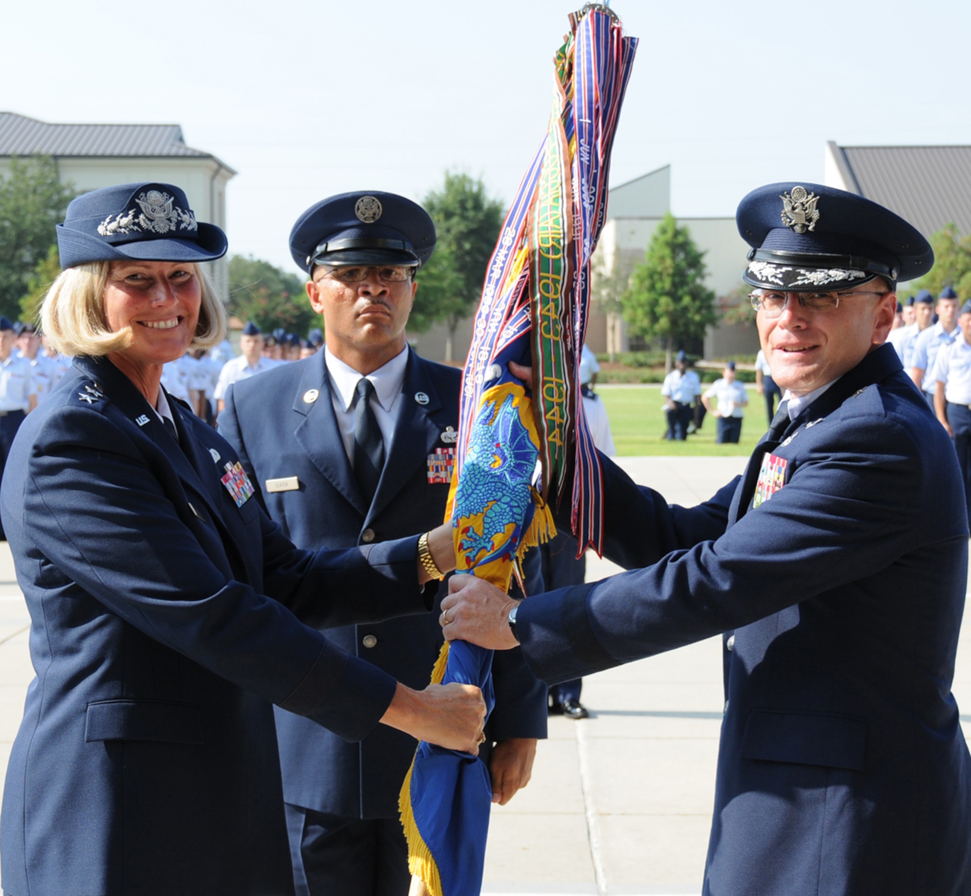 General Hertog passes the guidon to General Mueller as Chief Master Sgt. Lonnie Slater, 81st TRW command chief, looks on.  (U.S. Air Force photo by Kemberly Groue)