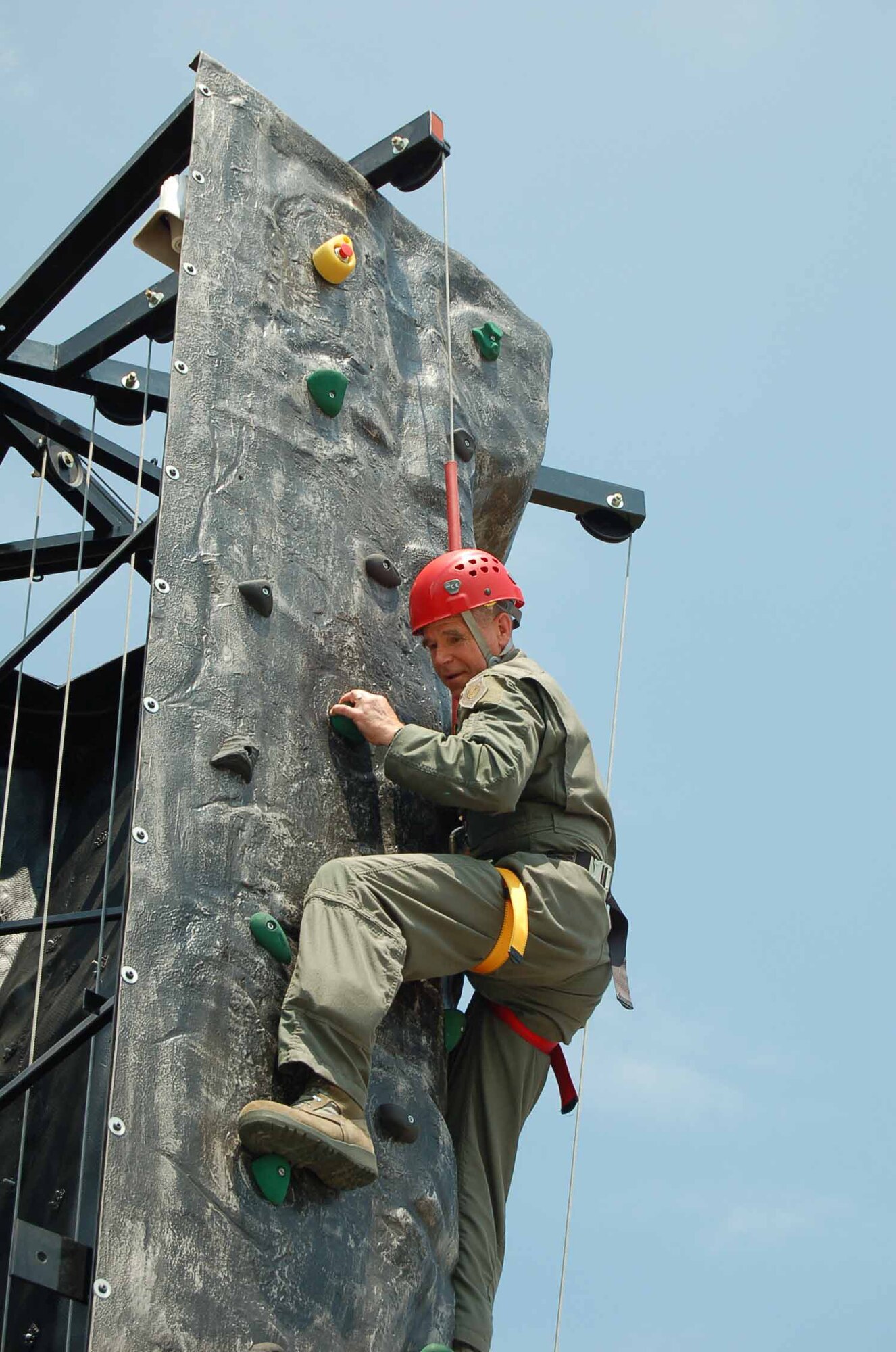 LANGLEY AIR FORCE BASE, Va.— Maj. Gen. William L. Holland, 9th Air Force commander, works his way up a mobile rock climbing wall during his visit to Junior Enlisted Appreciation Day July 29.  Agencies across the base joined forces to provide a day of food, fun and entertainment to thank military member in the ranks of E-1 through E-6 for their daily contributions in accomplishing the mission of Joint Base Langley Eustis. (U.S. Air Force photo/Master Sgt. Anna Hayman)