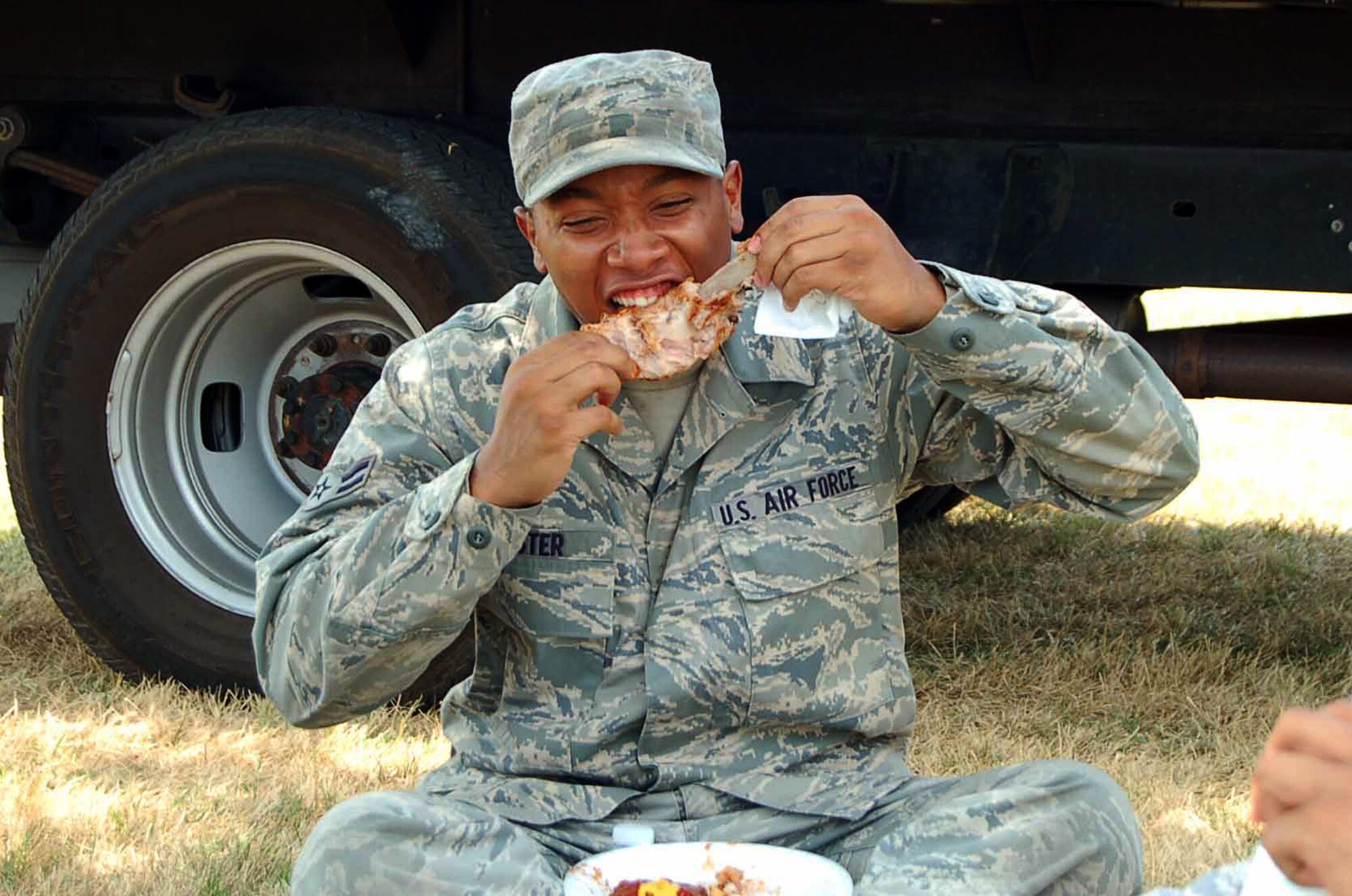 LANGLEY AIR FORCE BASE, Va.—Airman 1st Class Robert Lester of the 1st Component Maintenance Squadron enjoys a helping of barbecued ribs during Junior Enlisted Appreciation Day July 29.  Agencies across the base joined forces to provide a day of food, fun and entertainment to thank military member in the ranks of E-1 through E-6 for their daily contributions in accomplishing the mission of Joint Base Langley-Eustis. (U.S. Air Force photo/Master Sgt. Anna Hayman)