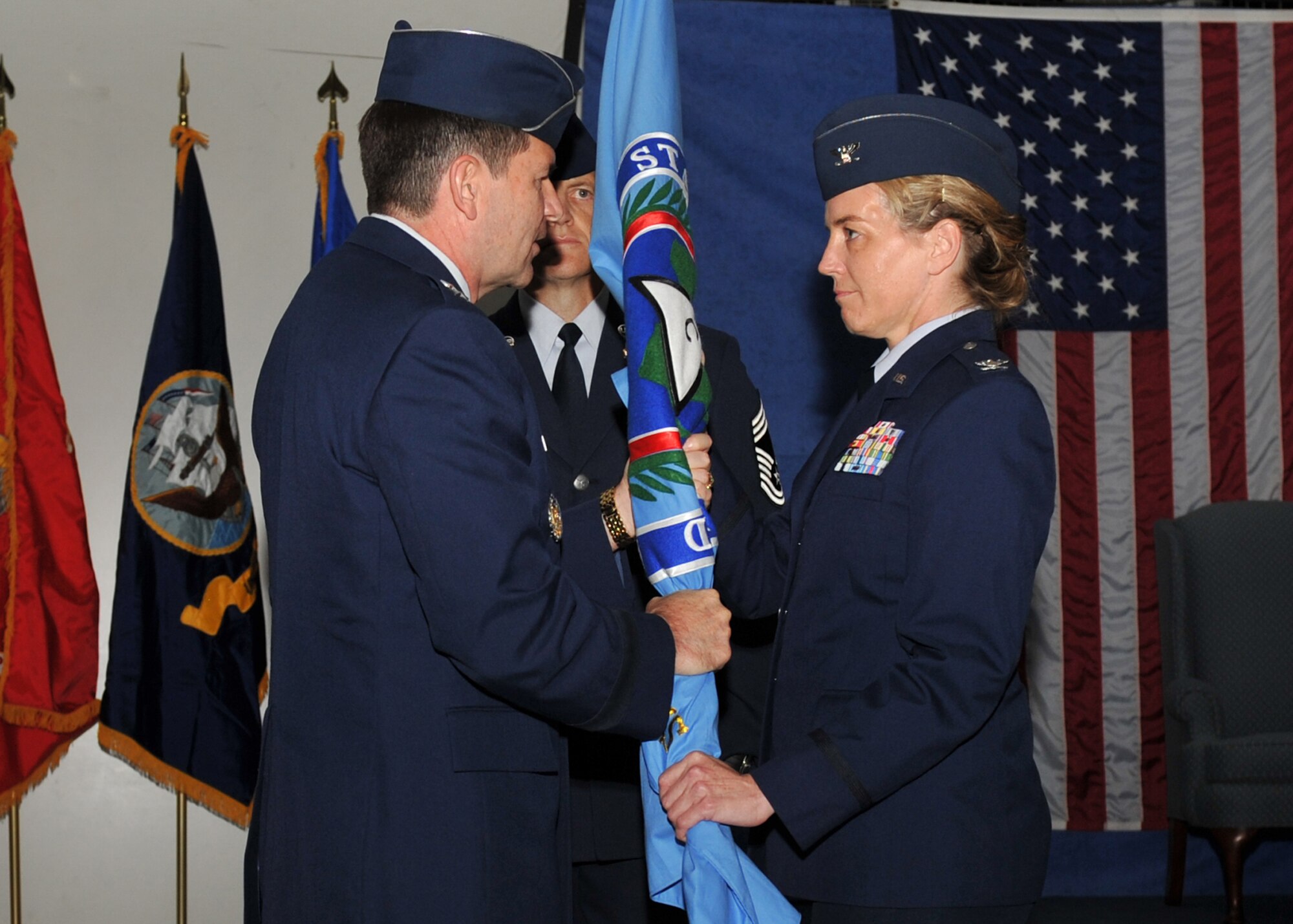 Colonel Michele M. Cook, new Commander of U.S. Africa Command's Intelligence & Knowledge Development Directorate - Molesworth is passed the unit guidon by AFRICOM Chief of Staff, Major General Michael Snodgrass, during a transfer of authority and assumption of command ceremony conducted at Royal Air Force Molesworth, England, July 7, 2010.  (Photo by U.S. Air Force Staff Sgt. Javier Cruz)