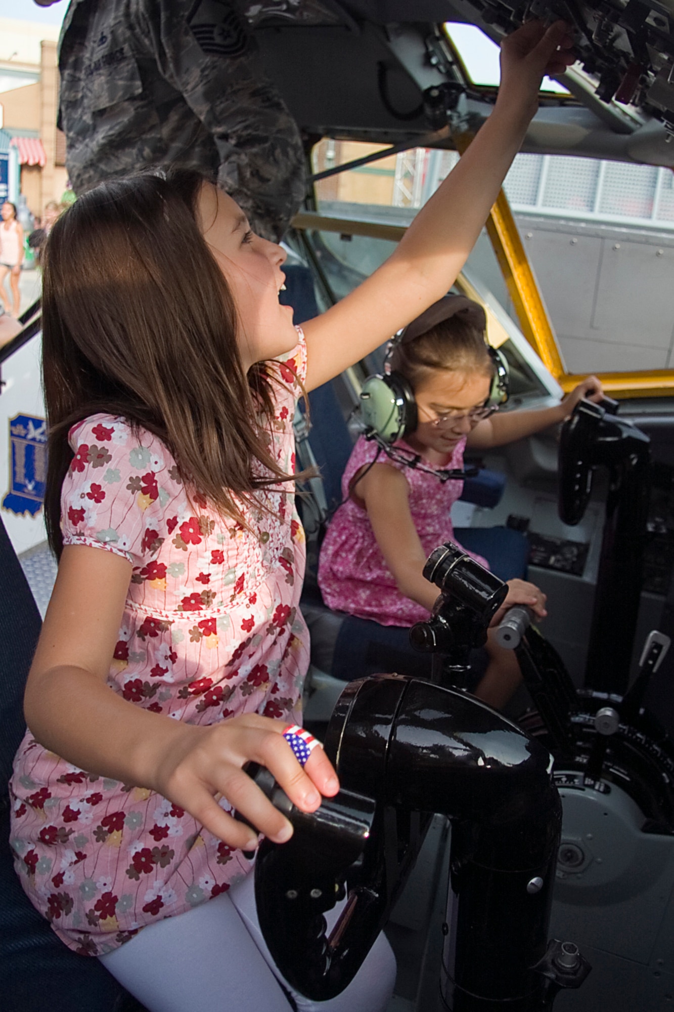 GRISSOM AIR RESERVE BASE, Ind. -- Julia, left, and Sara Bailey take their turn in the cockpit of a KC-135R Stratotanker. The two sisters were at an Indianapolis Indians game where they got their chance behind the stick in a cockpit simulator from the 434th Air Refueling Wing. Members of the 434th ARW and Air Force Reserve recruiters took part in opening ceremonies at the game and brought with them a cockpit and boom pod display, which were featured behind center field. (U.S. Air Force photo/Tech. Sgt. Mark R. W. Orders-Woempner) 