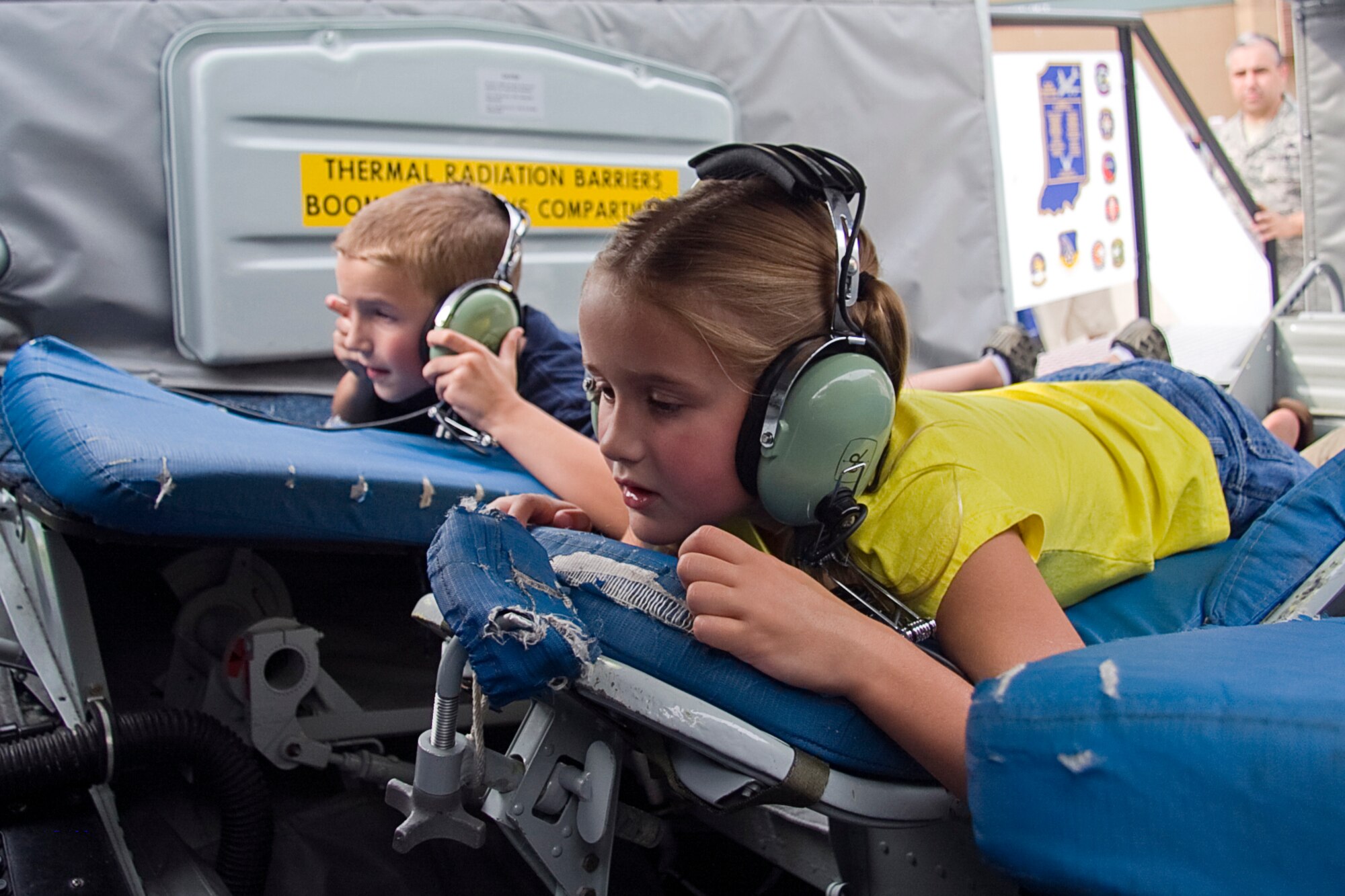 GRISSOM AIR RESERVE BASE, Ind. -- Kennedy Fisher, 6, and Josh Worman, 8, watch and listen to an aerial refueling mission that is being played on a screen in a KC-135R Stratotanker boom pod simulator July 22. The two were able to climb inside and get a hands-on experience of what Airmen from the 434th Air Refueling Wing do every day. Both the boom pod and flight deck simulators were on display during an Indianapolis Indians game at Victory Field in Indianapolis.  (U.S. Air Force photo/Tech. Sgt. Mark R. W. Orders-Woempner) 