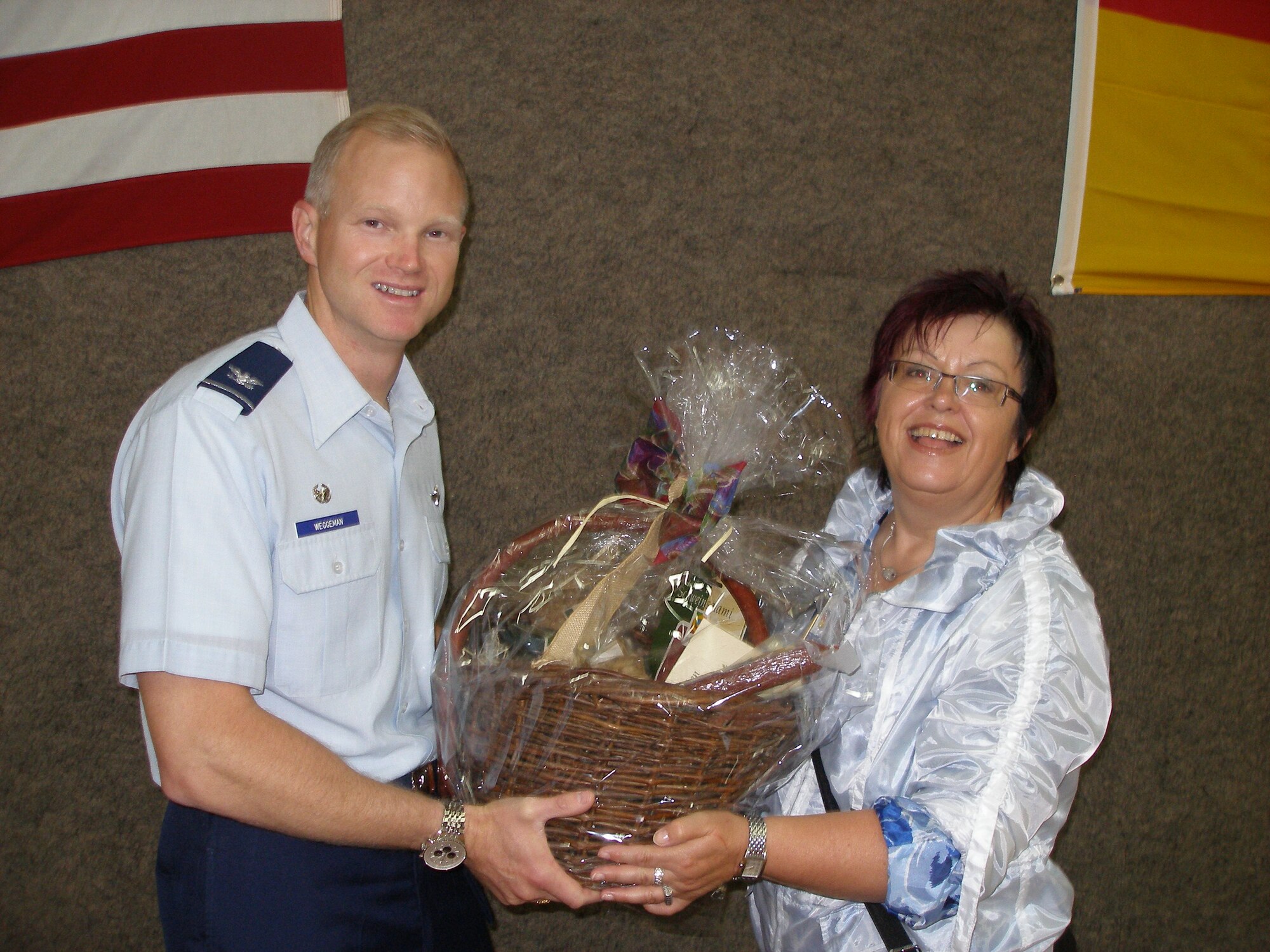 Col. Christopher Weggeman, 52nd Fighter Wing commander, receives a basket with regional Eifel products from Monika Fink, member of the Rheinland-Pfalz state parliament. On behalf of the Bitburg-Pruem county, Ms. Fink thanked the 52nd FW for promoting German-American relations in the region during Explore the Eifel. Local politicians praised the annual program at Spangdahlem Air Base, which is unique throughout the Air Force. (Courtesy photo by Hillarius Esch)